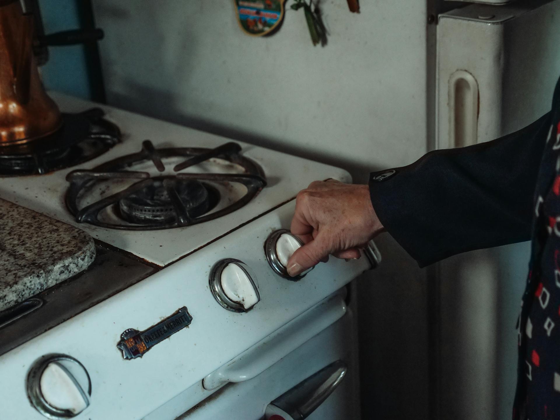 A person holding a stove knob | Source: Pexels