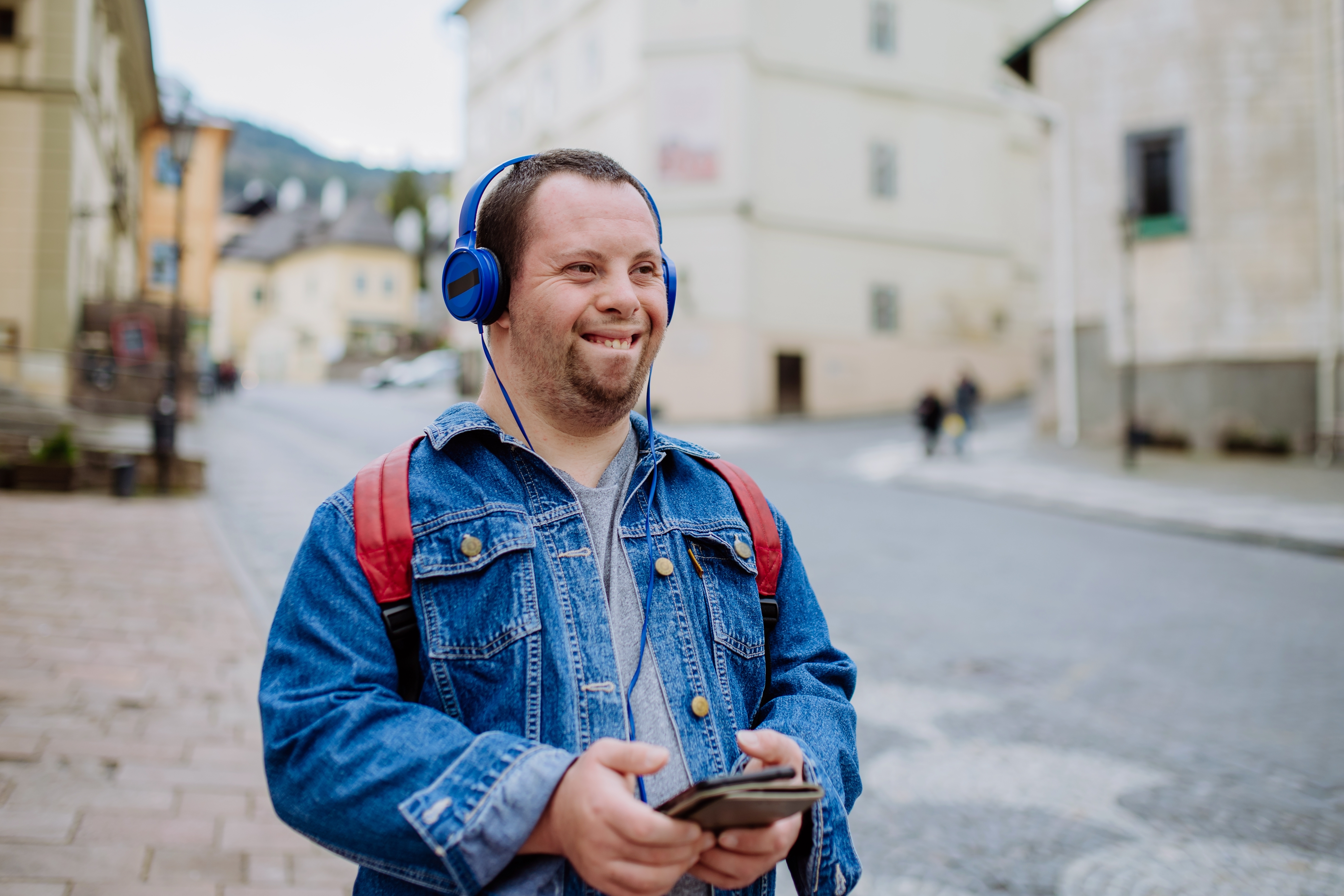 A man with Down sydrome listening to music while walking in street. | Source: Shutterstock