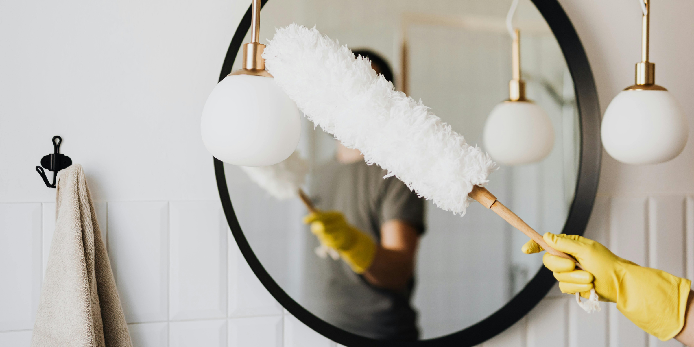 Dusting a glass mirror | Source: Pexels