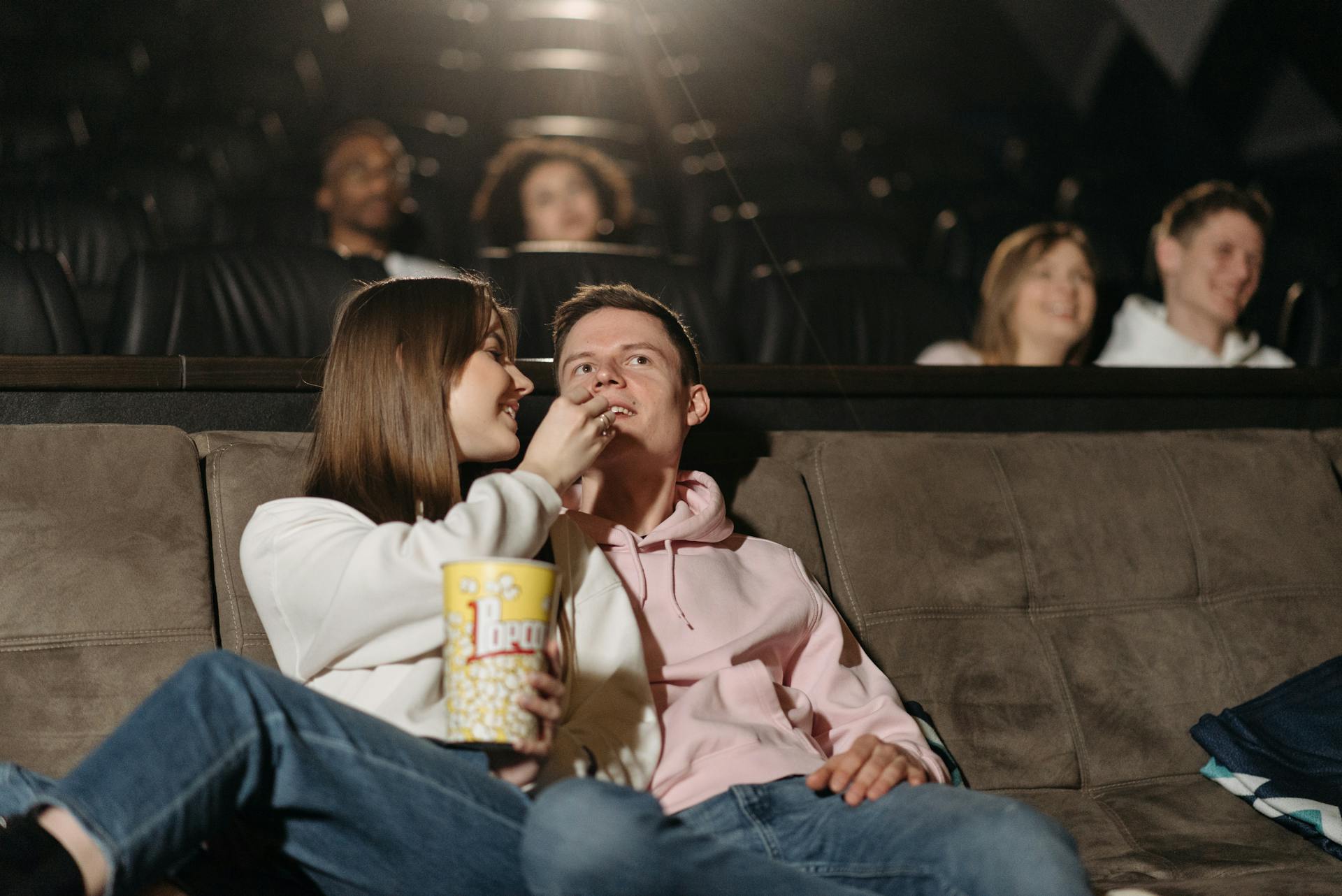 Couple eating popcorn while watching a movie in a cinema | Source: Pexels