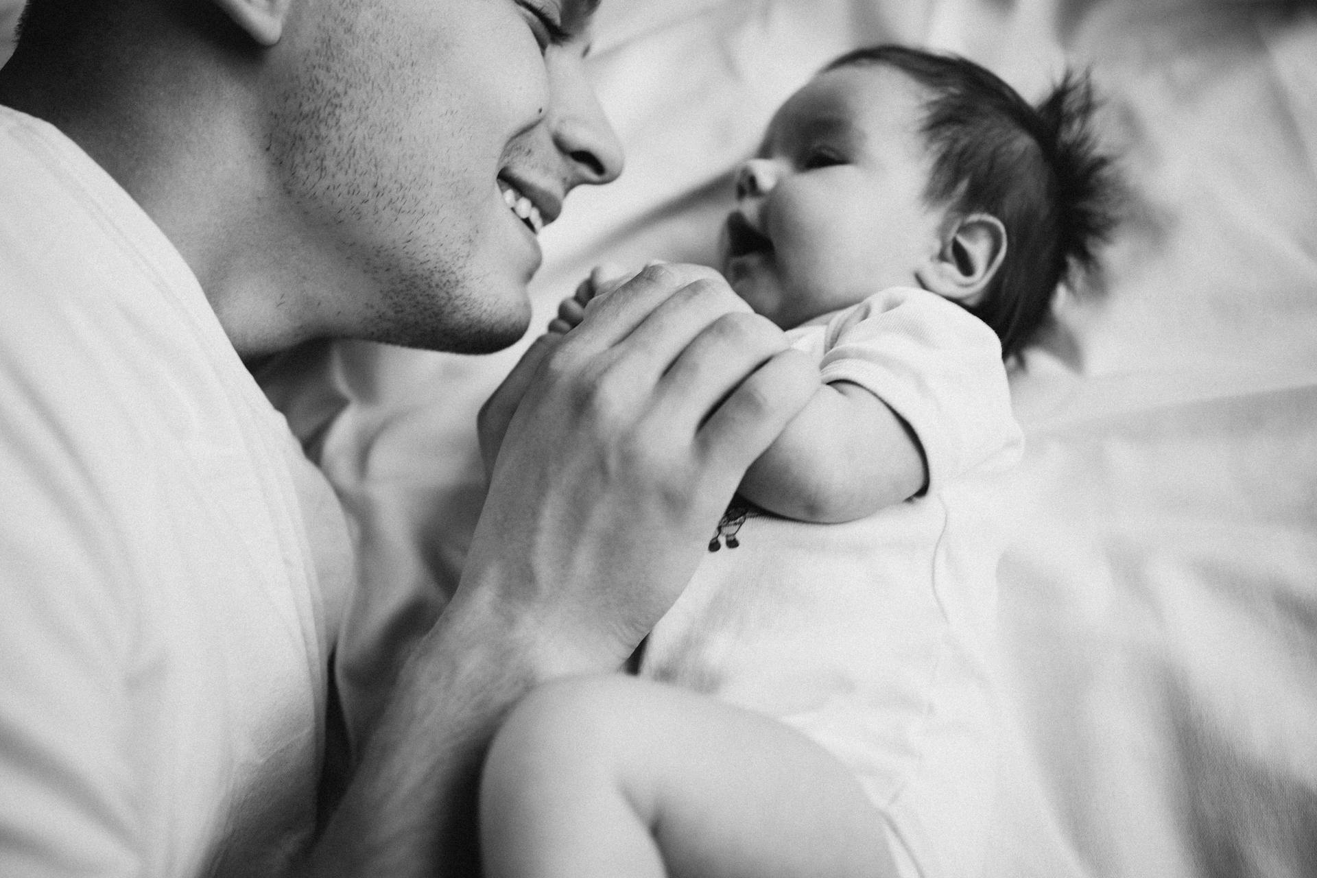 A father lying on bed with his newborn baby | Source: Pexels