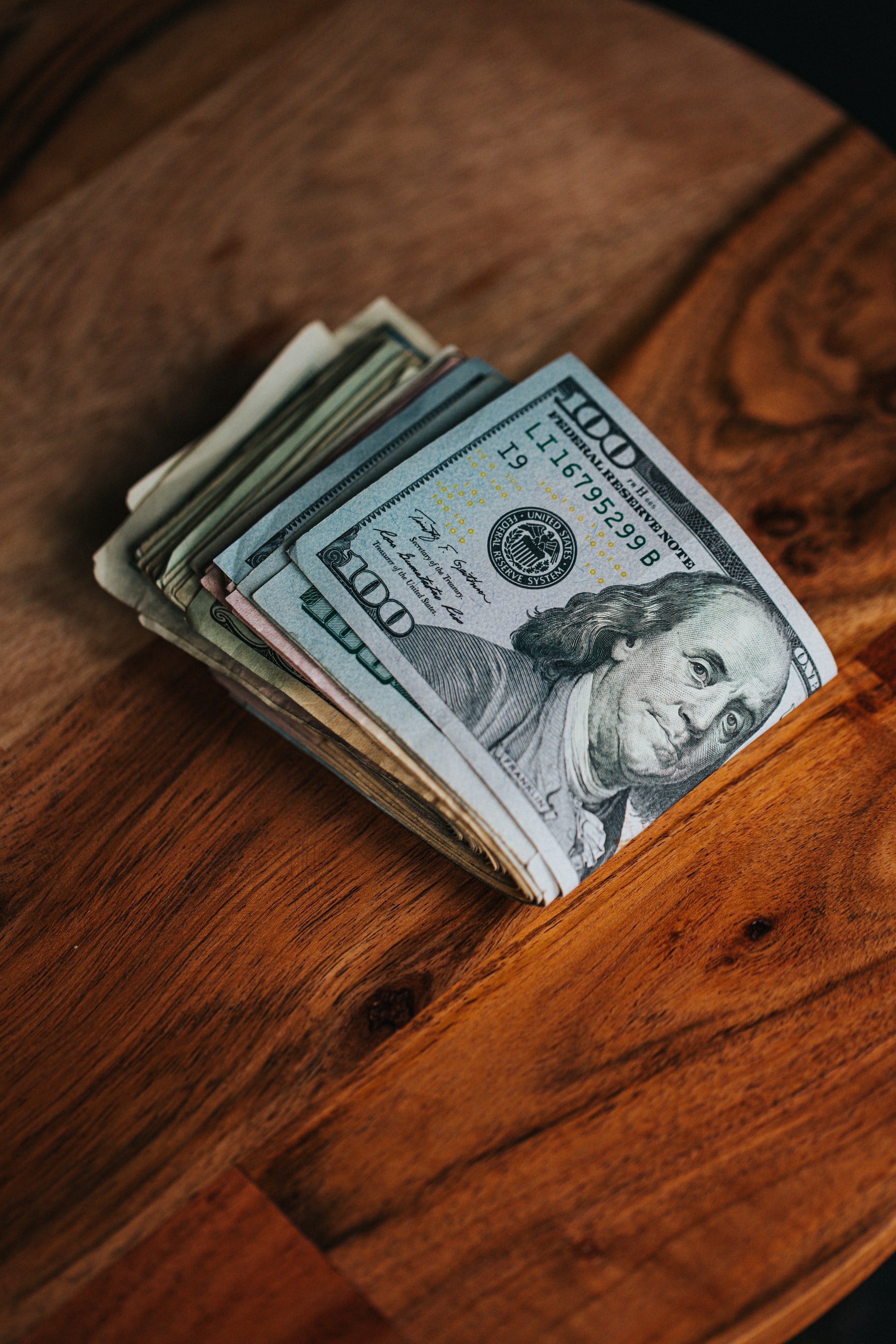 Money on a wooden table | Source: Unsplash