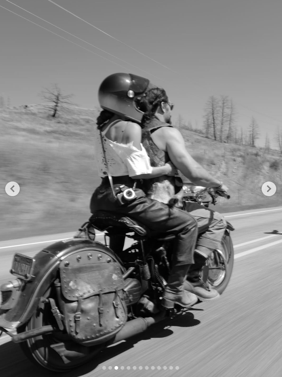 Adria Arjona sits behind Jason Momoa as he rides a motorcycle, in a photo dated August 1, 2025 | Source: Instagram/adriaarjona