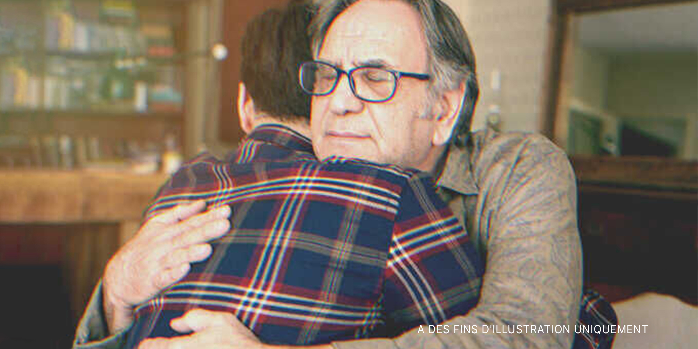 Homme âgé serrant un jeune homme dans ses bras | Source : Shutterstock