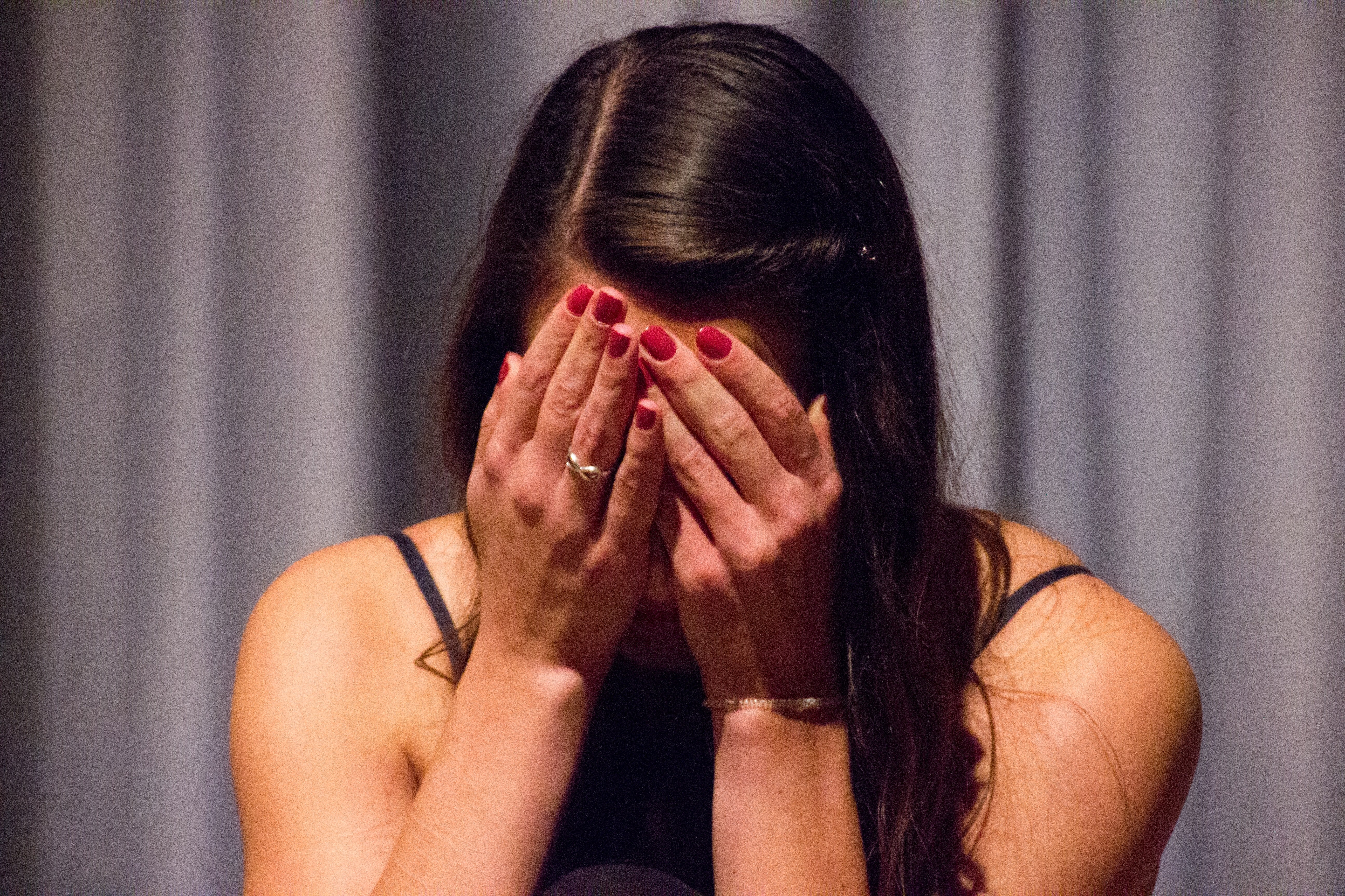 Una mujer avergonzada cubriendo su rostro con sus manos. | Foto: Unsplash