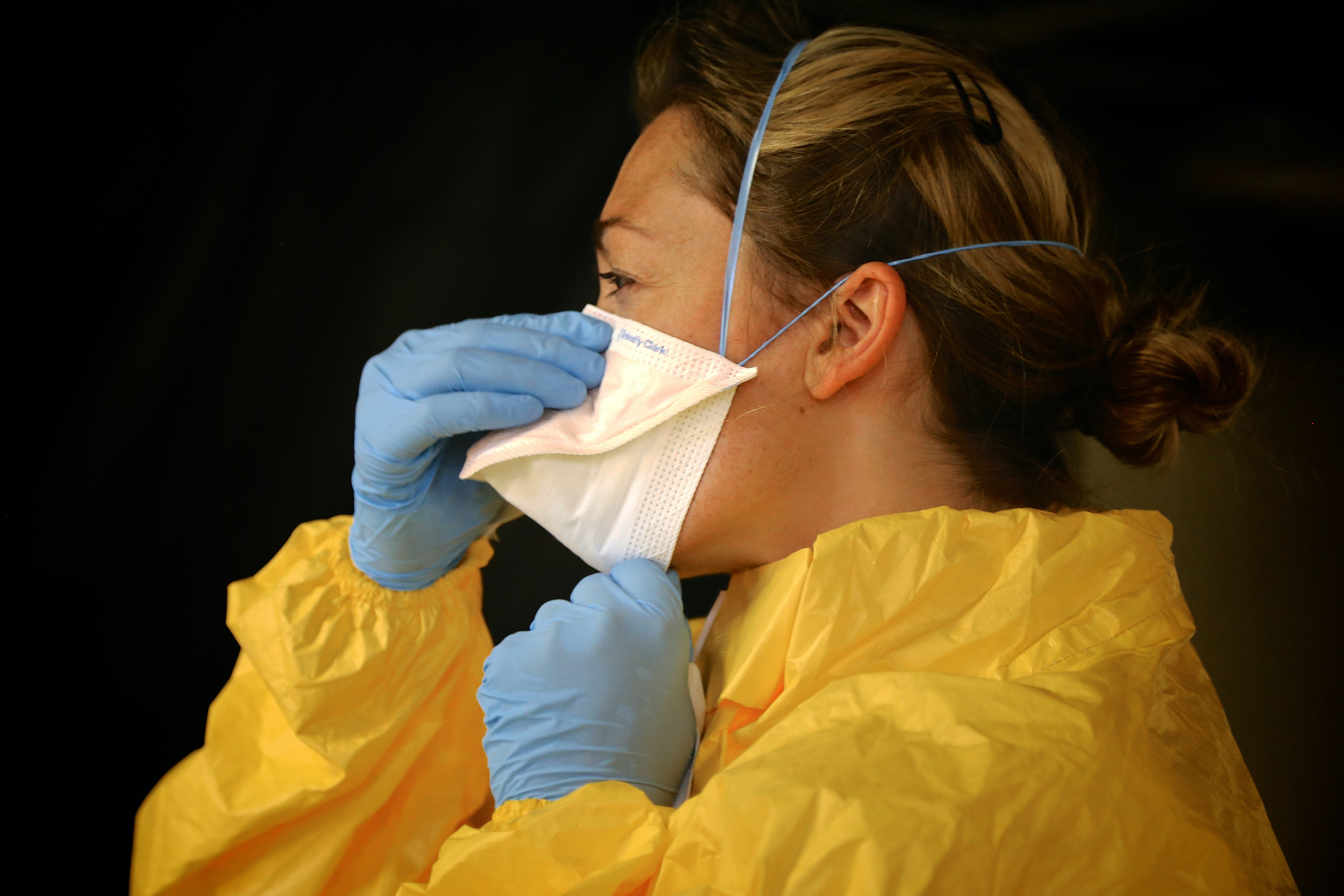A frontline worker puts on her mask. | Source: Pexels/CDC