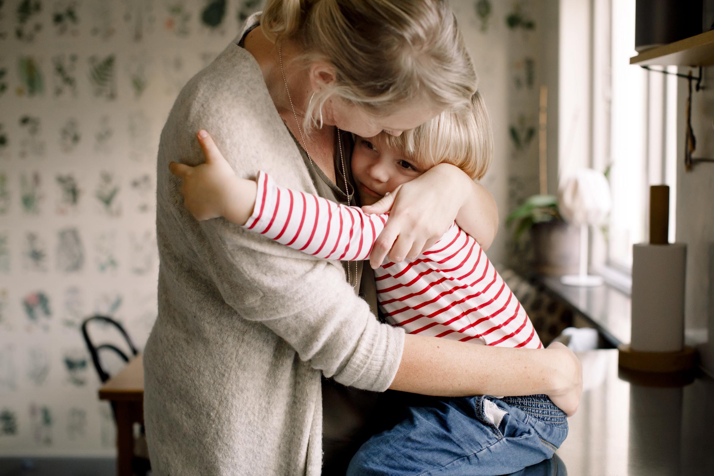 A mom hugging her daughter in her kitchen | Source: Getty Images