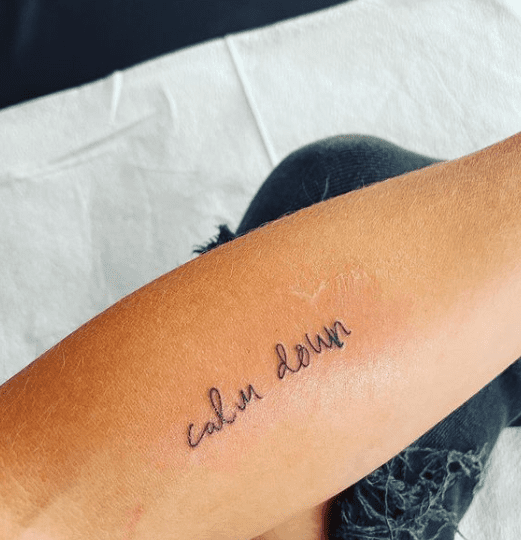 The words "calm down" tattooed on Hilarie Burton's forearm in honor of late Willie Garson | Photo: Instagram.com/hilarieburton/