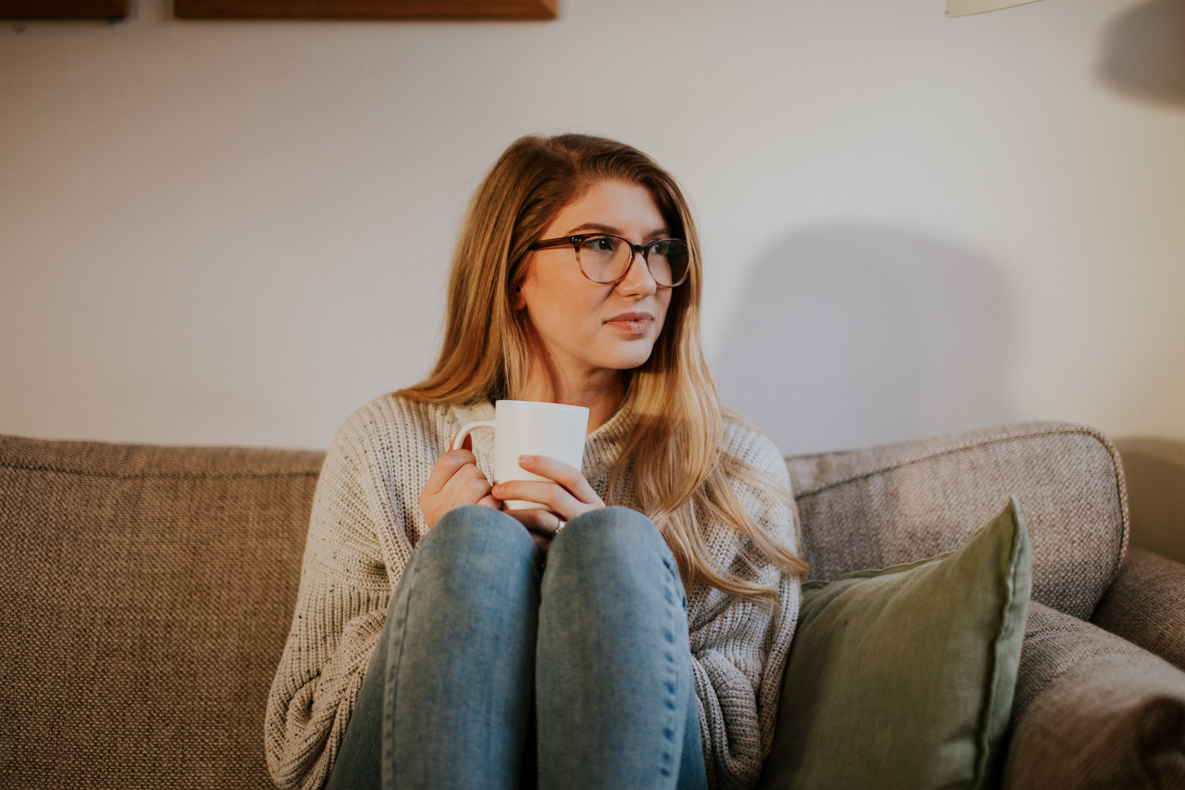 Woman sitting on couch and thinking | Source: Unsplash