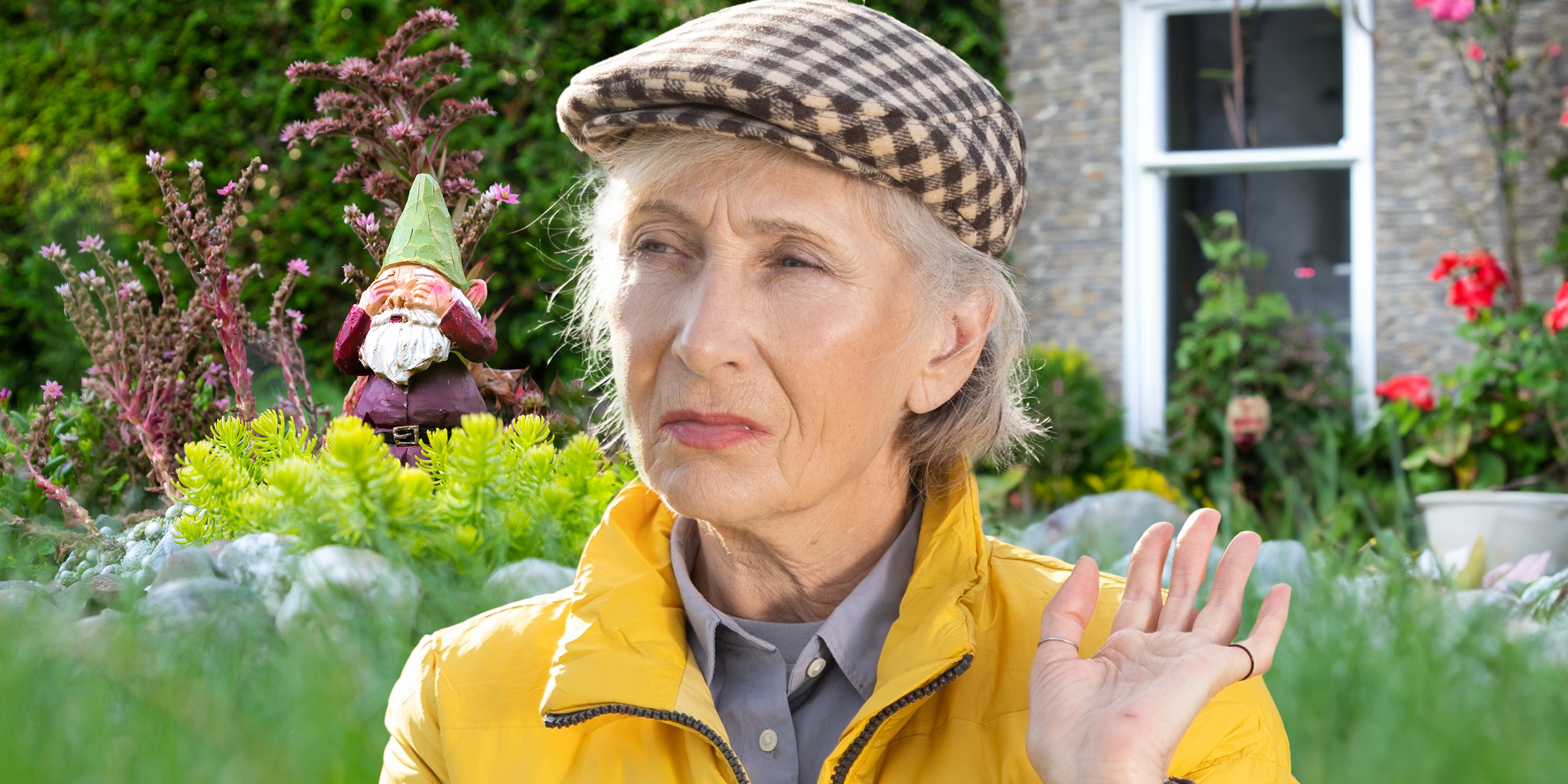 An older woman with a garden gnome in the backdrop | Source: Shutterstock