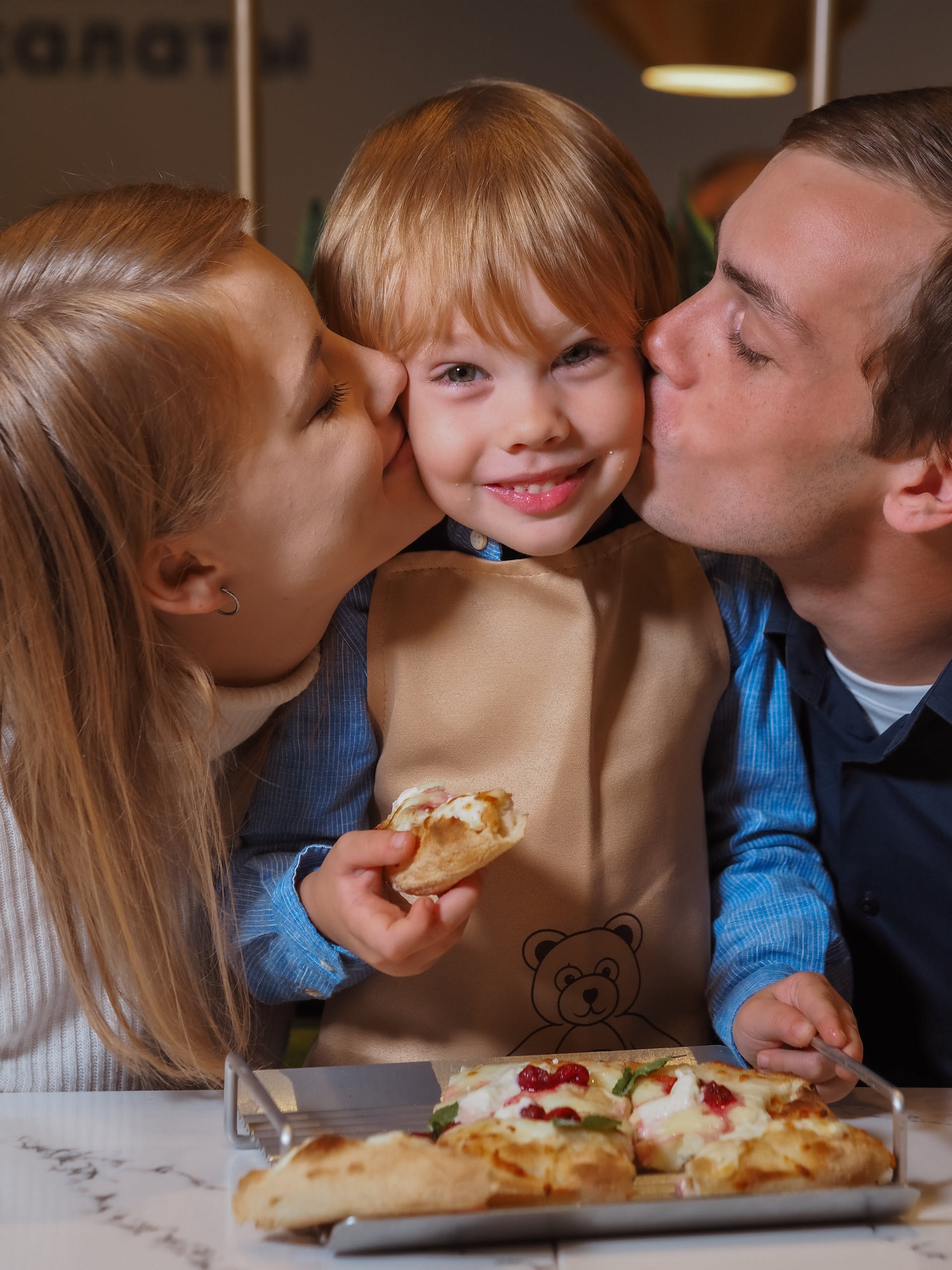 A couple kissing their little son | Source: Pexels