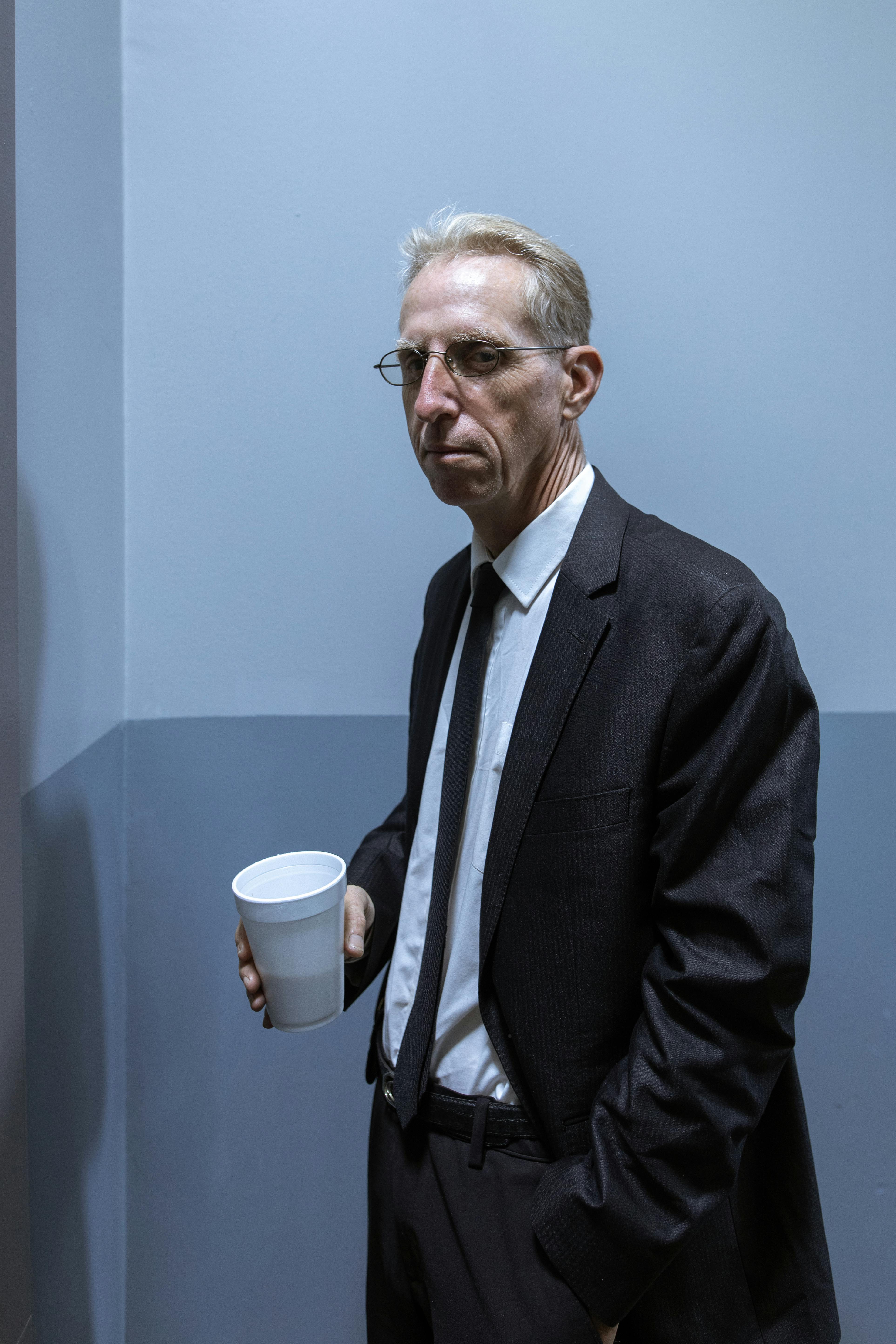 An older man in a suit holding a coffee cup | Source: Pexels