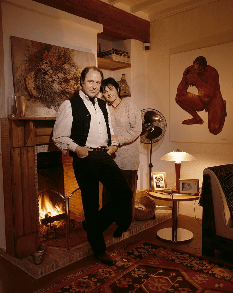 Michel DELPECH et son épouse Geneviève, debout devant la cheminée. | Photo : Getty Images