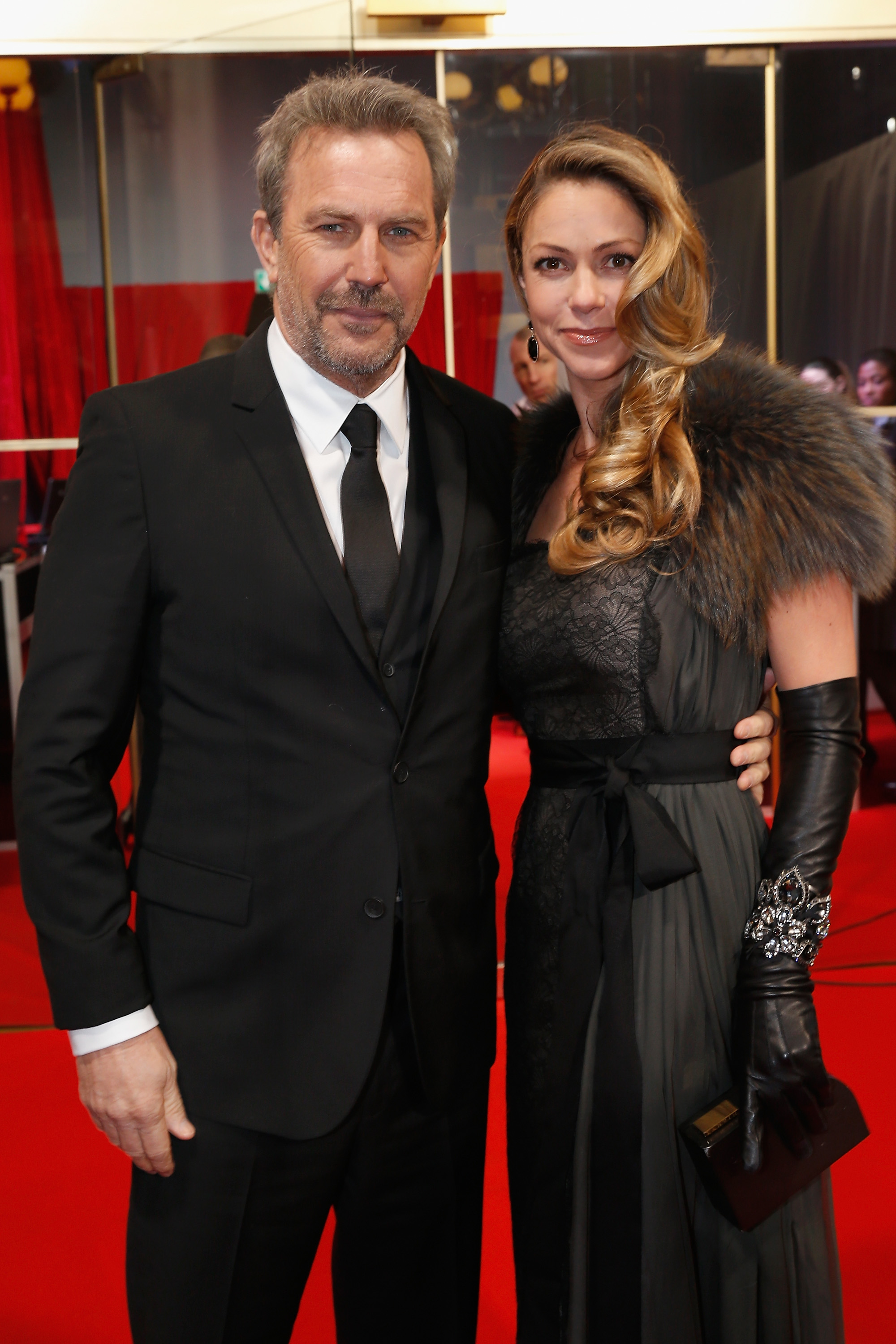 Kevin Costner and Christine Baumgartner embraced Old Hollywood elegance at the César Awards in Paris, with Costner in a classic black suit and Christine turning heads in a dramatic fur-trimmed gown and jeweled gloves. The couple exuded sophistication on the red carpet.