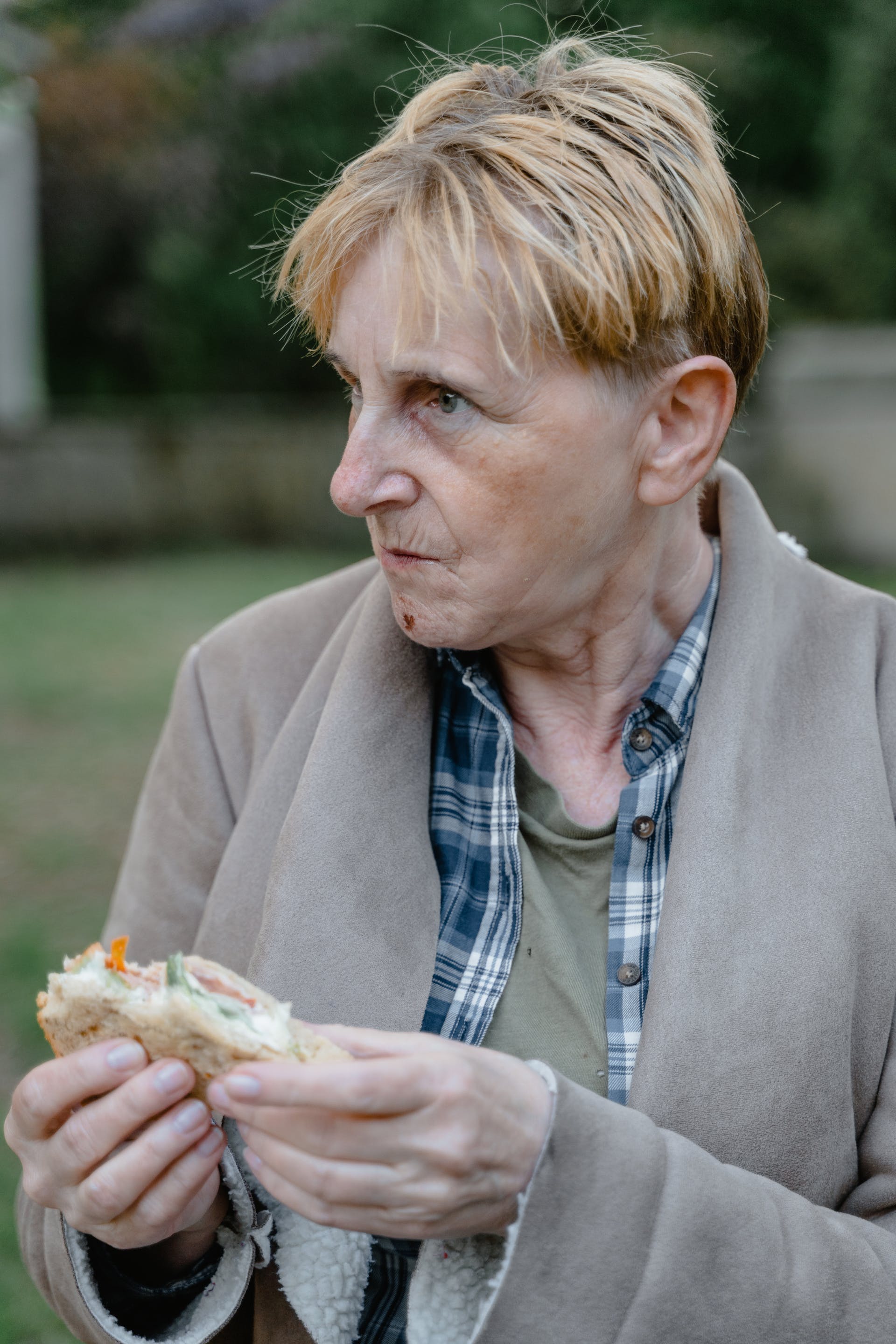 An older woman holding a sandwich | Source: Pexels