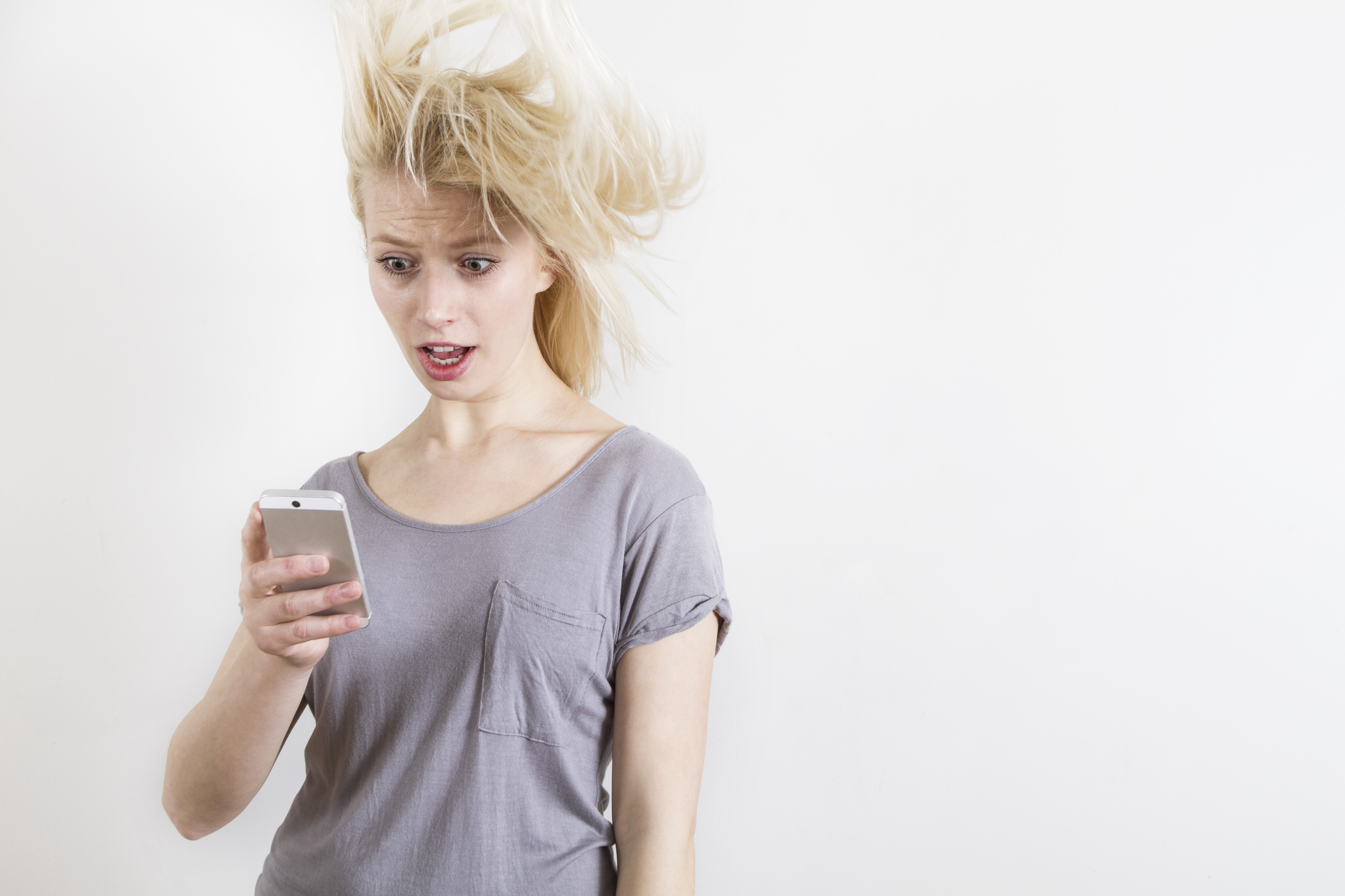 Woman with shocked expression looking at phone | Source: Getty Images