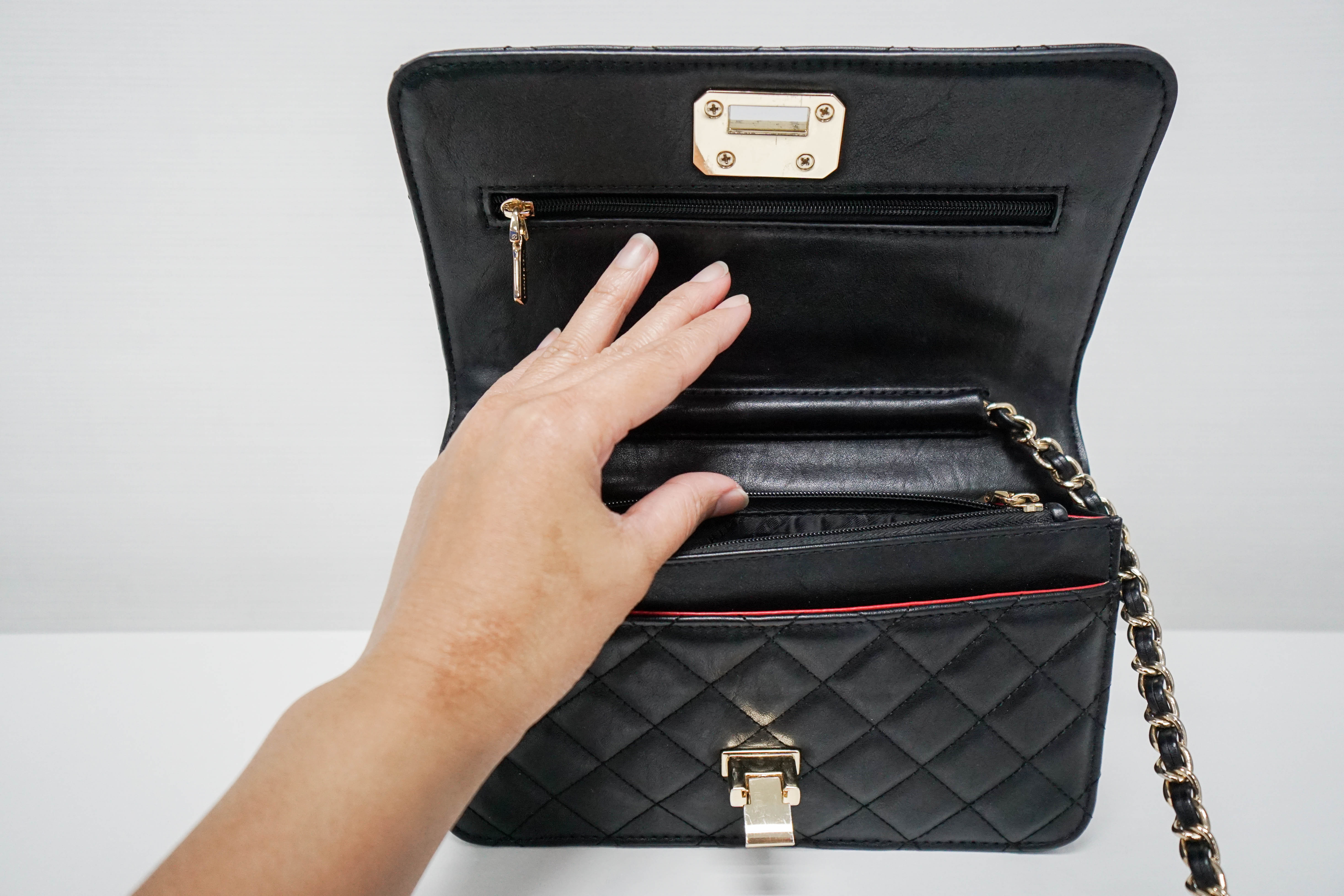A hand holding a handbag open | Source: Shutterstock