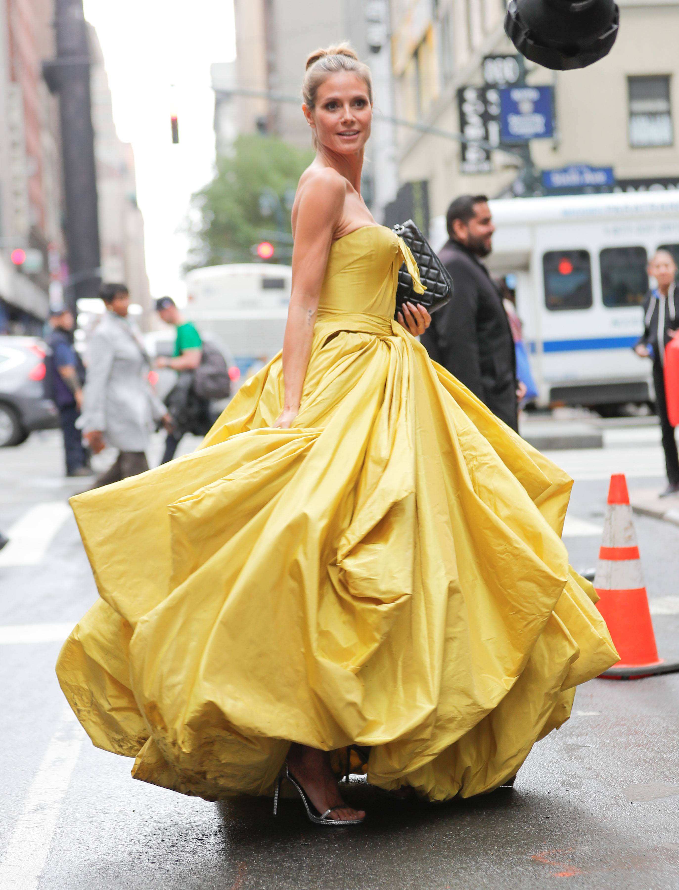 Heidi Klum does a photoshoot in a canary yellow Zac Posen dress for Project Runway on June 6, 2017 in New York City. | Source: Getty Images