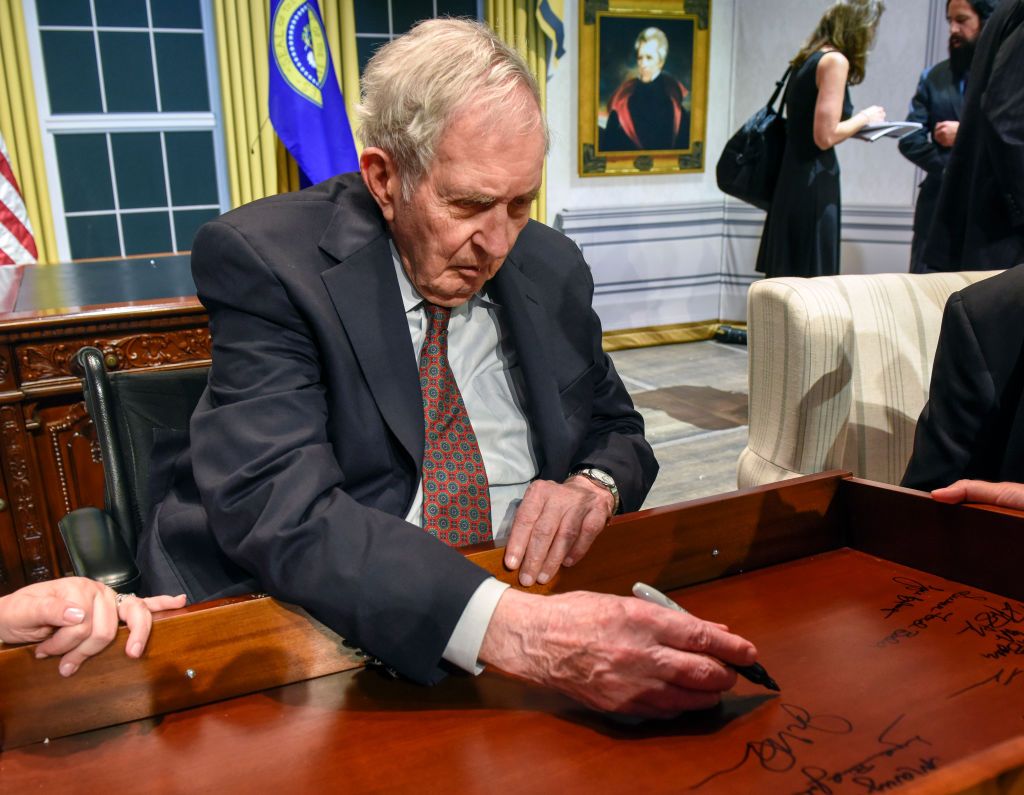 Lyon Gardiner Tyler Jr. signs his name on the inside of a desk drawer with other descendants of past Presidents gathered for a panel discussion at the Kennedy center, on August, 28, 2018 in Washington, DC | Photo: Getty Images