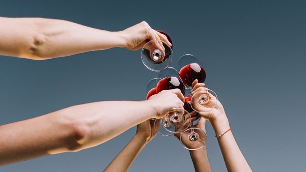Personas brindando con copas de vino. │Foto: Freepik