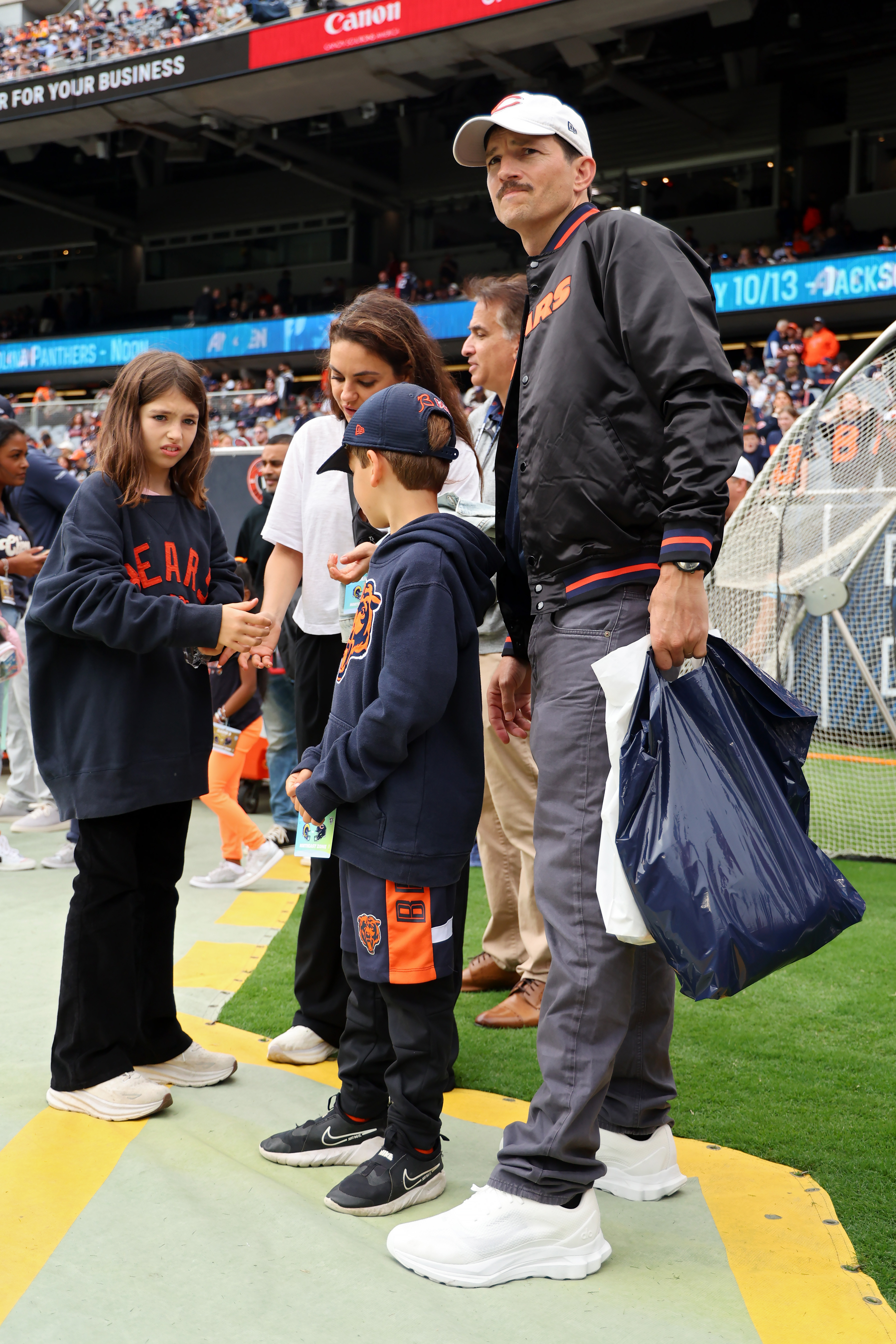 Ashton, Wyatt, and Dimitri Kutcher with Mila Kunis at a game between the Chicago Bears and the Los Angeles Rams in Chicago, Illinois on September 29, 2024 | Source: Getty Images