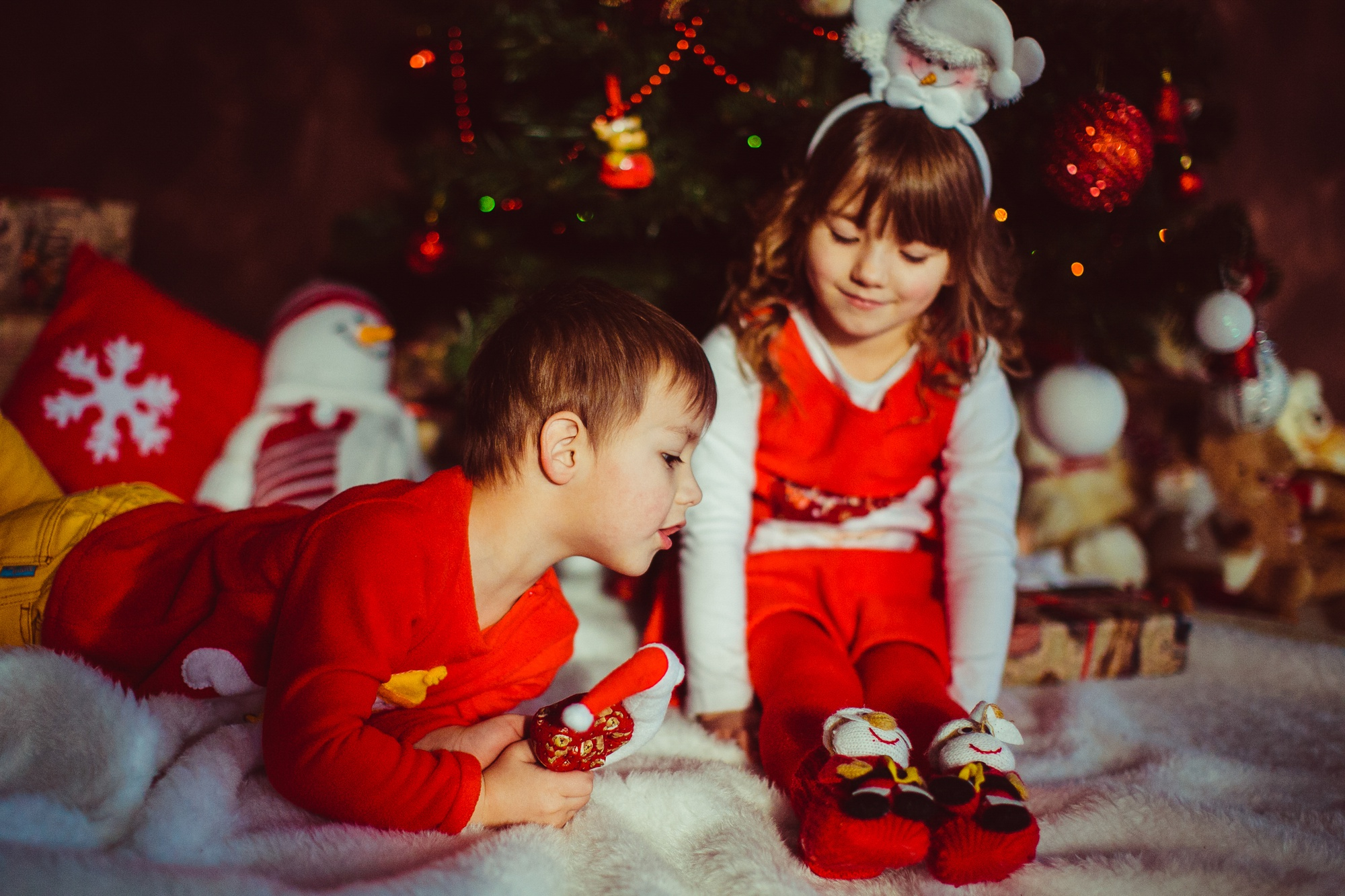 Kids playing beside a Christmas tree | Source: Freepik