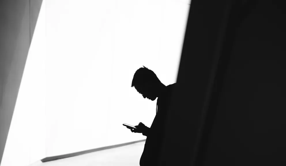 L'homme vérifie son téléphone après qu'une notification s'affiche à l'écran | Photo : Unsplash