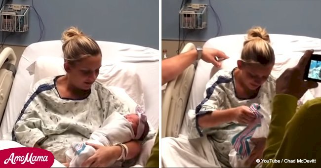 Mother cradling her newborn baby suddenly sees a message hidden beneath the blanket