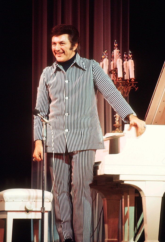 Liberace (1919 - 1987) performs on stage, UK, circa 1983. | Getty Images