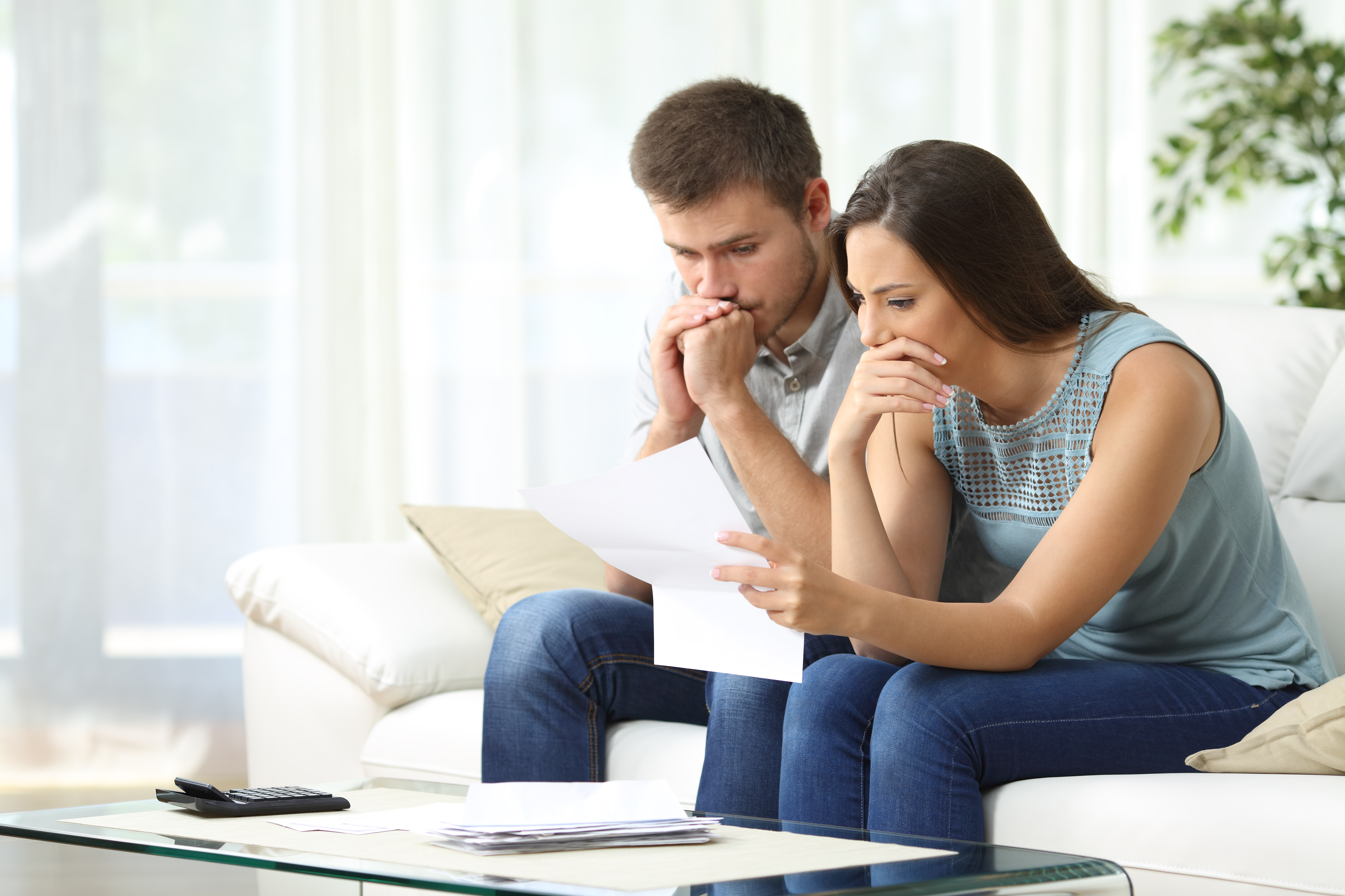 Una pareja preocupada mirando un documento | Fuente: Shutterstock