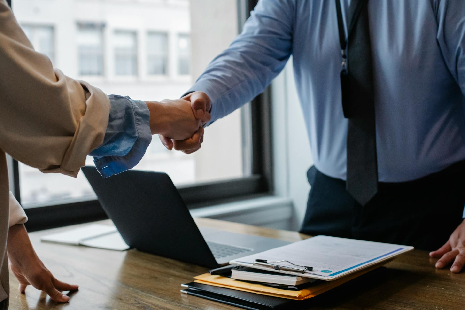A supervisor shaking hands with their employee in the office | Source: Pexels