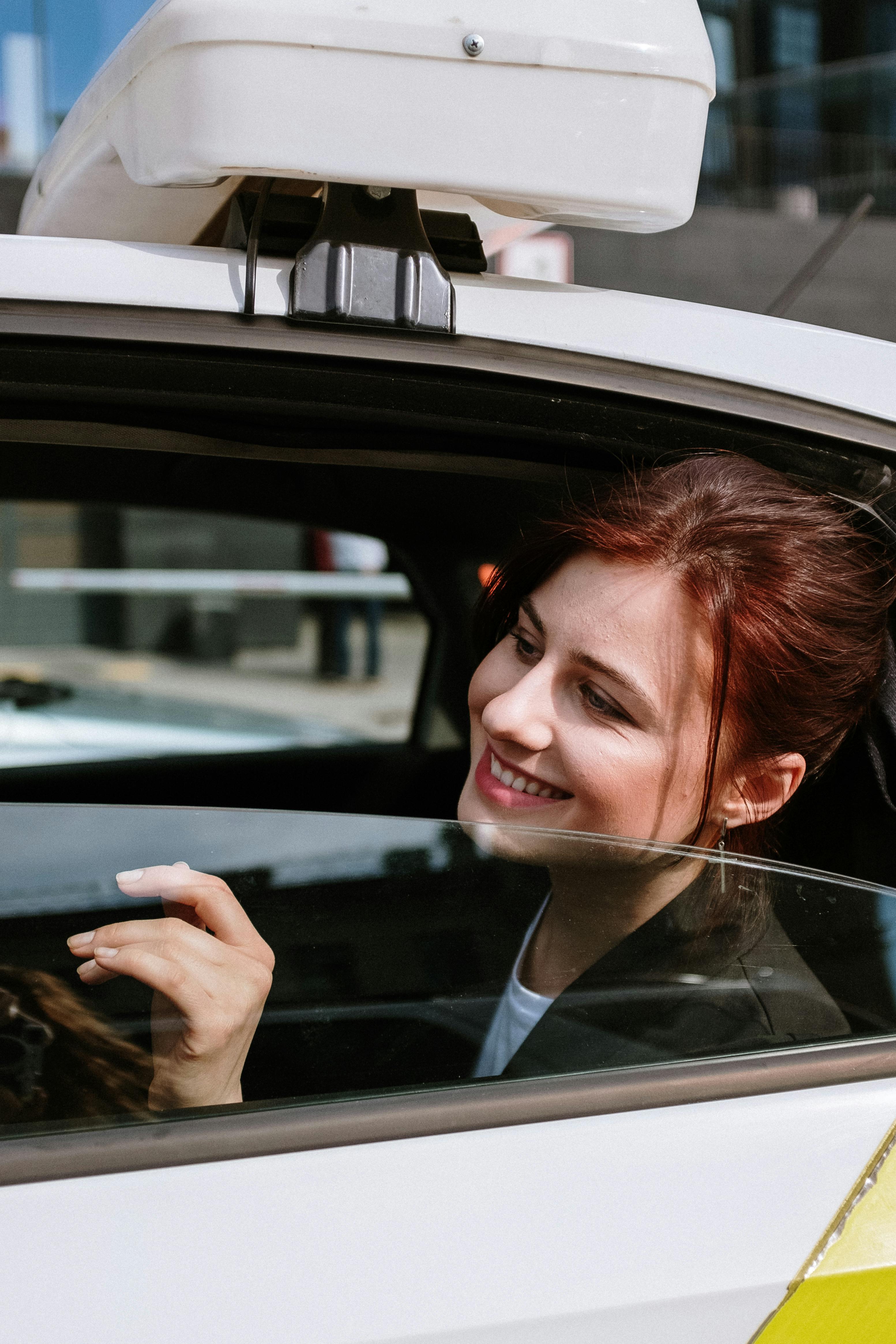 A smiling woman looking out a car window | Source: Pexels