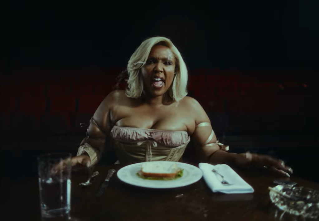 A tense moment unfolds as Lizzo reacts at the table | Source: YouTube/Lizzo