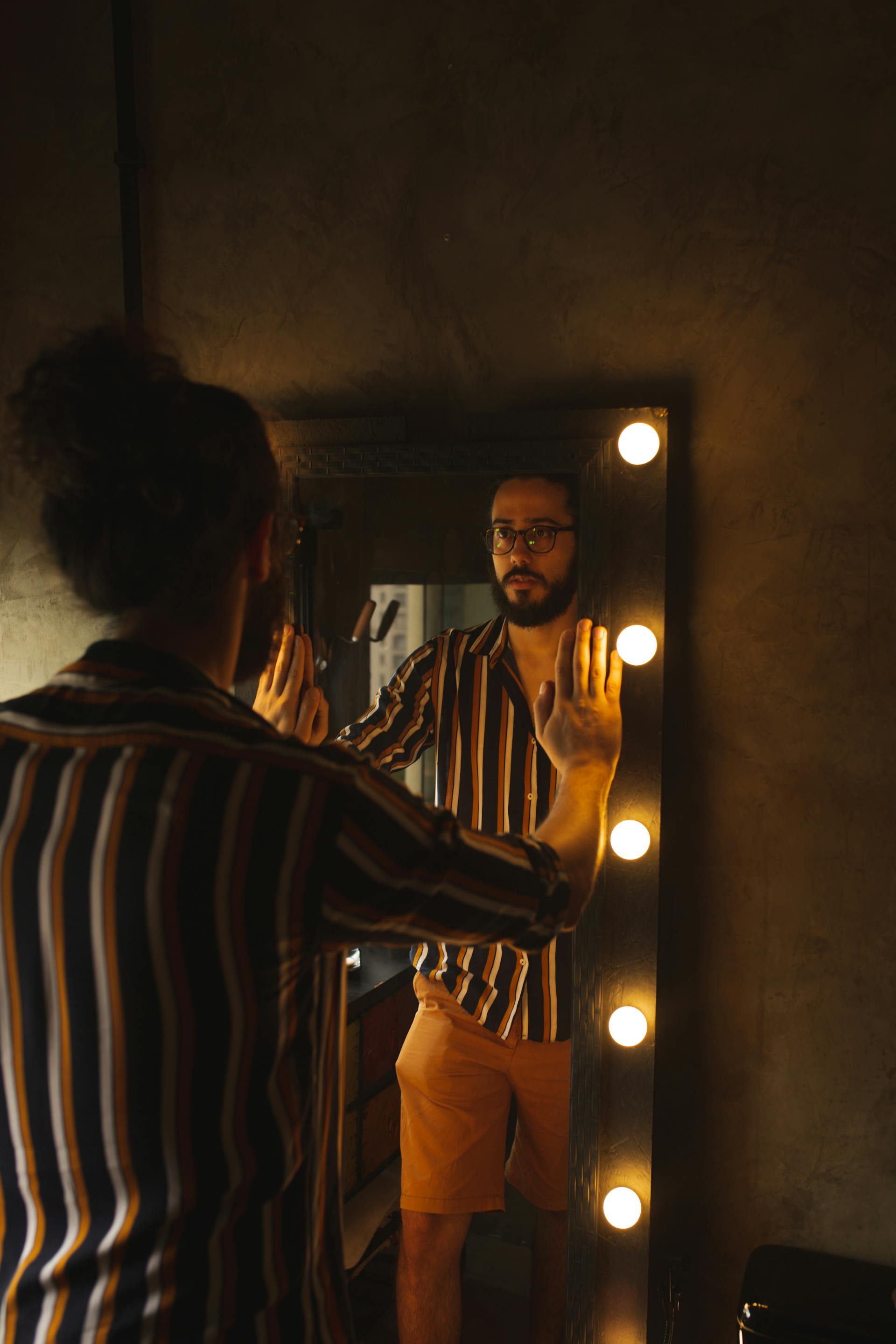 A man looking at his reflection in the mirror | Source: Pexels