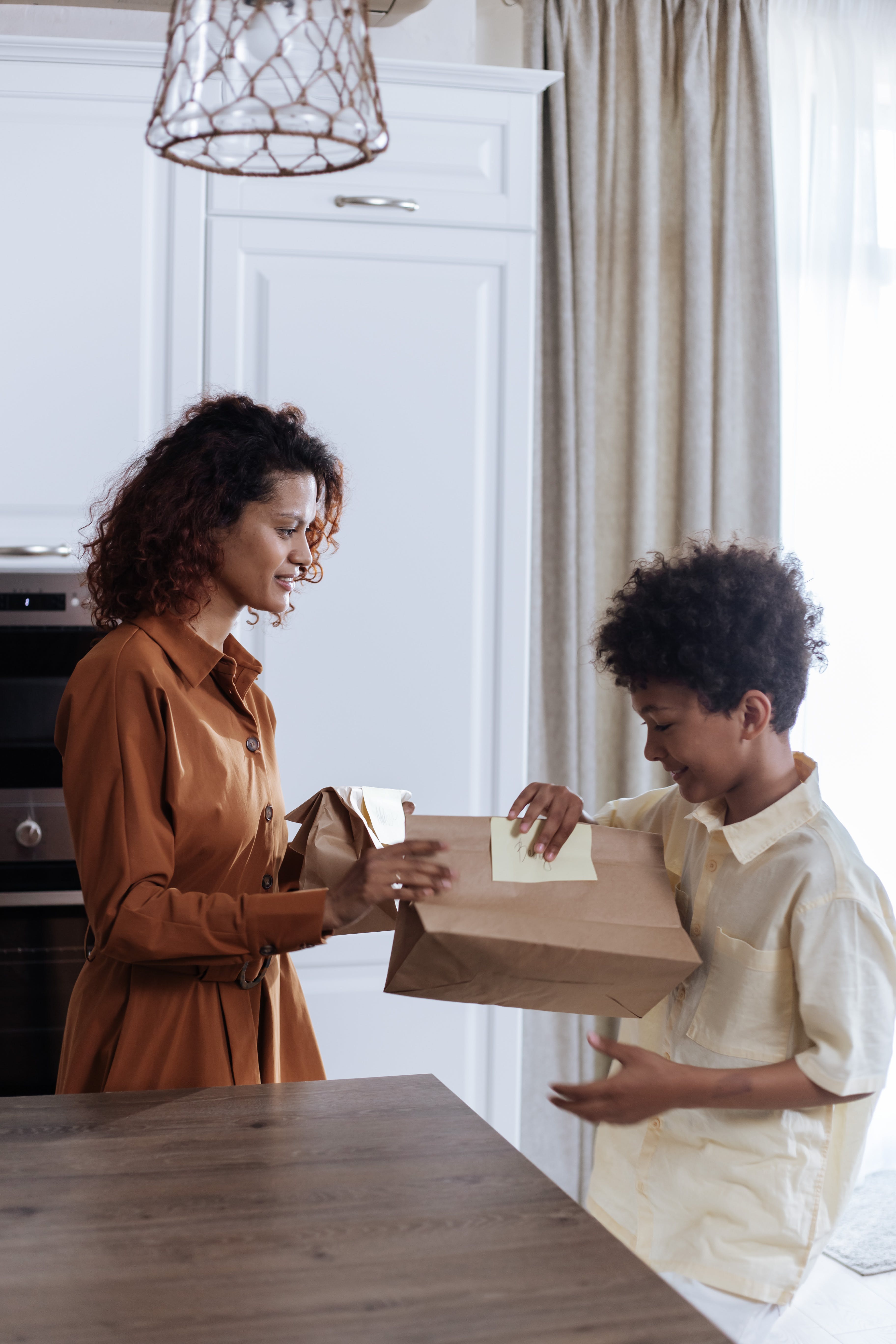 A mom giving her son a lunch bag | Source: Pexels