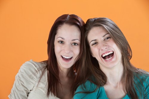 Two girlfriends laughing out loud. | Source: Shutterstock.
