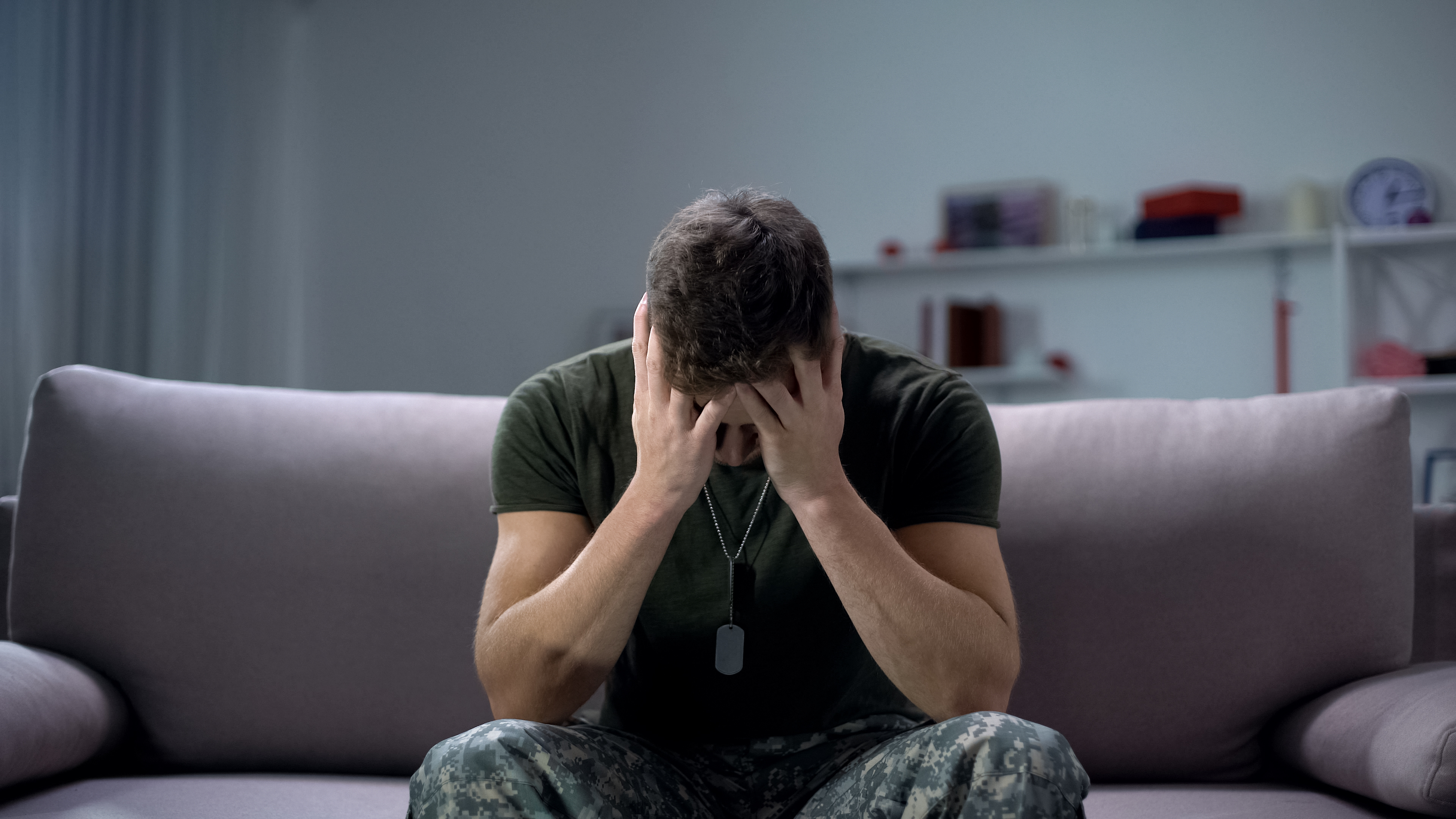 A man sitting while holding his head | Source: Shutterstock