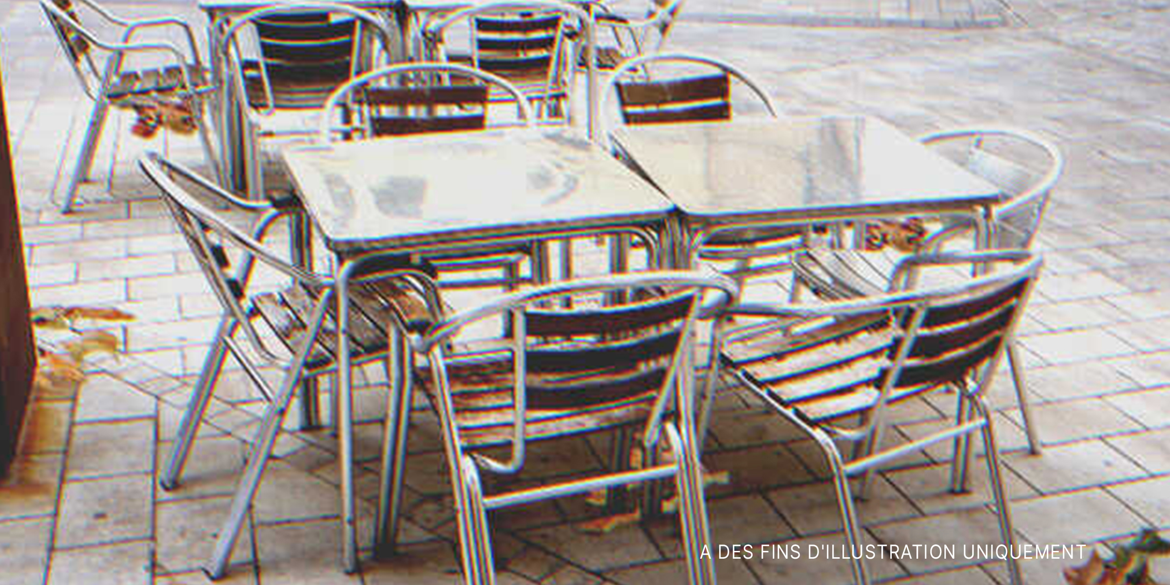 Des tables et des chaises en métal sur le trottoir à l'extérieur d'un café | Source : Getty Images