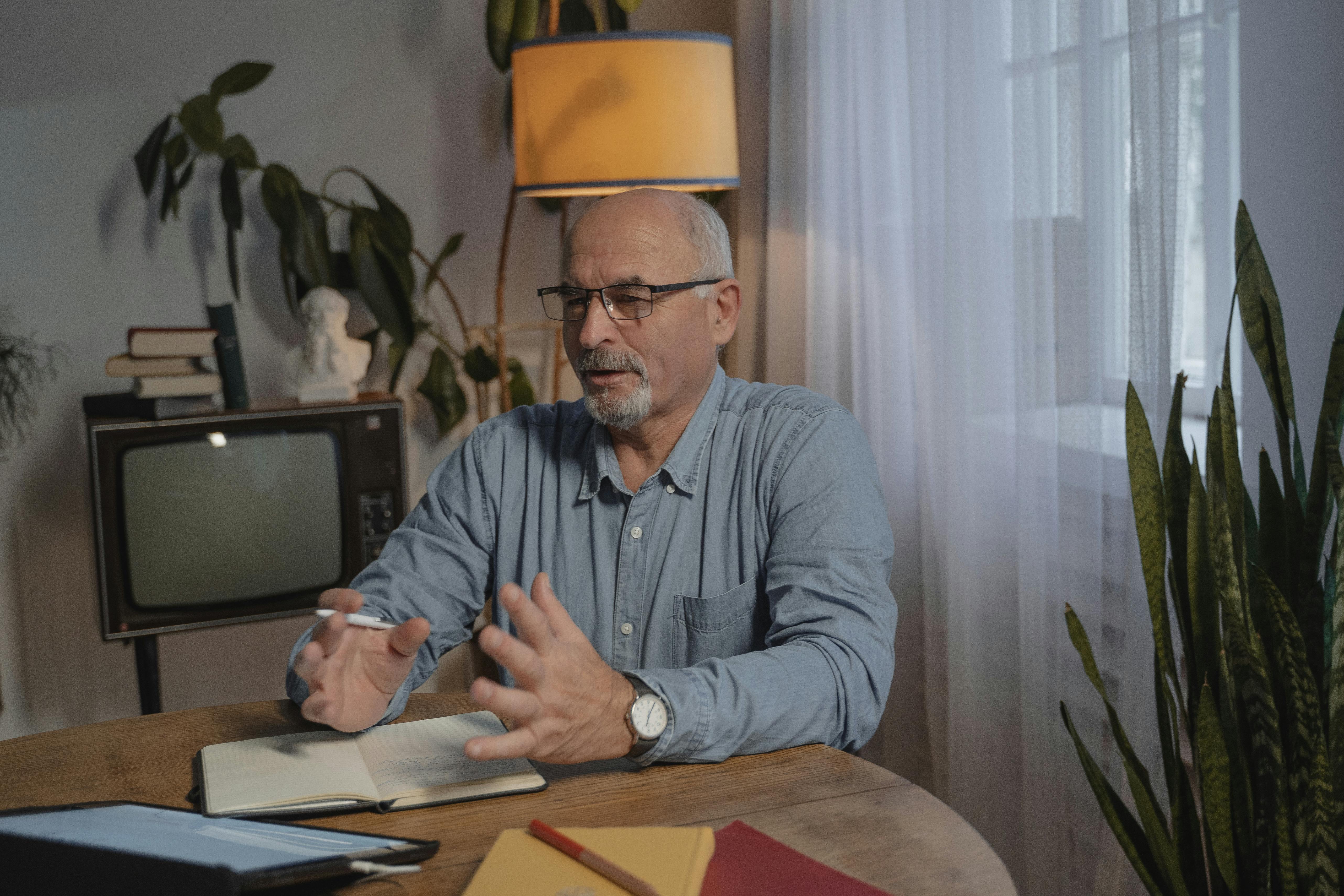 A middle-aged man talking while wearing glasses | Source: Pexels