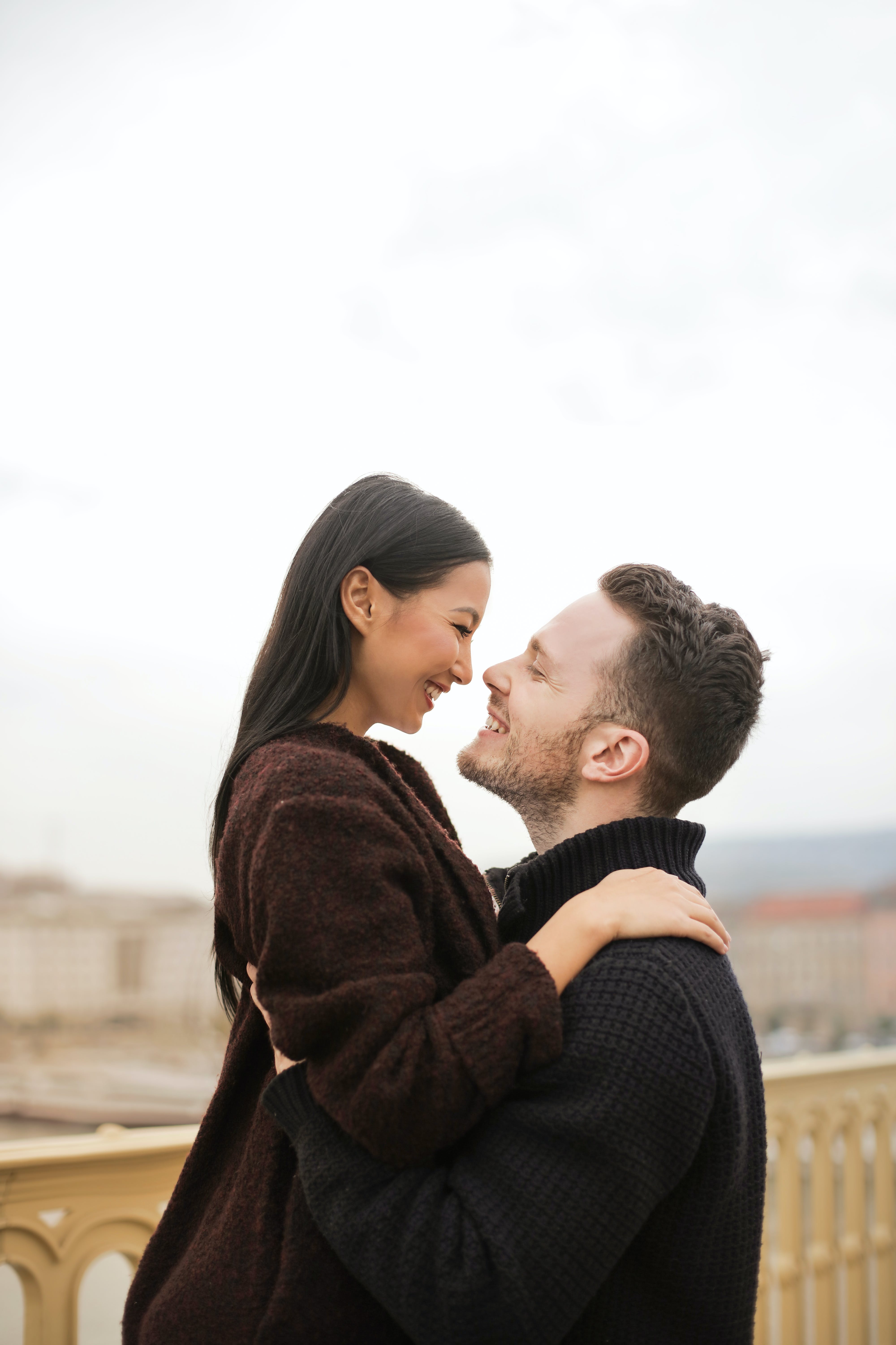 A boyfriend smiling while happily lifting his girlfriend | Source: Pexels
