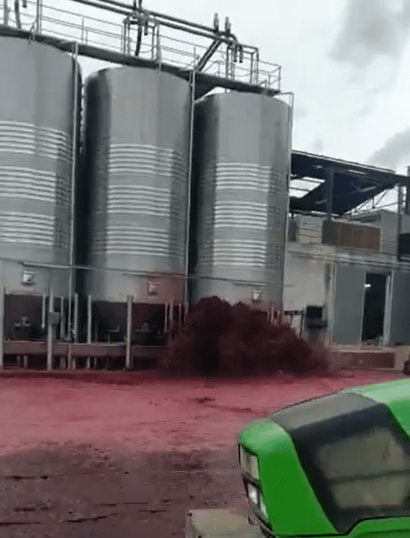 Red wine spraying out of a large metal vat in Spain in September 2020. | Photo: Twitter/@jamesglynn 