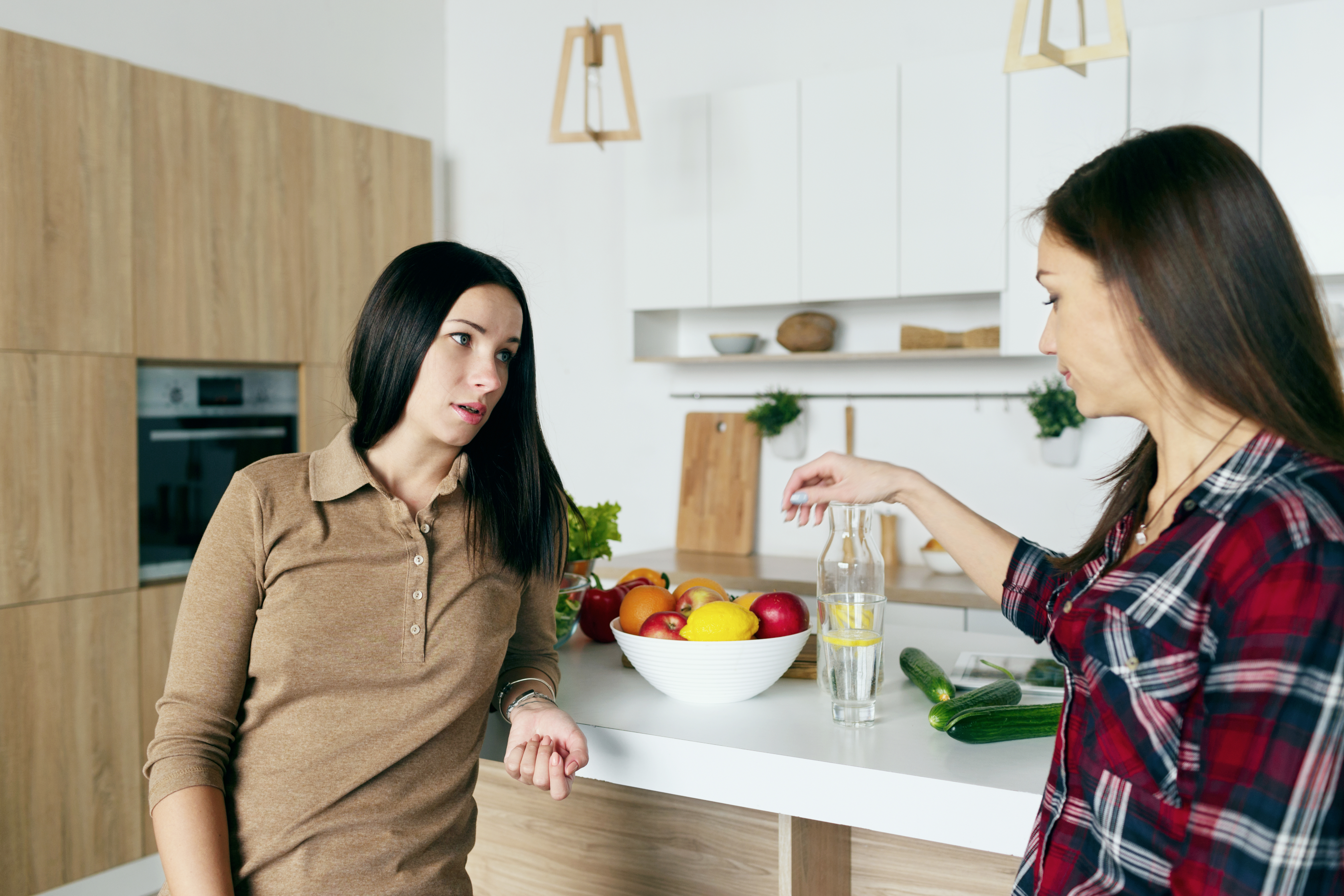 Two women having a conversation in the kitchen | Source: Shutterstock