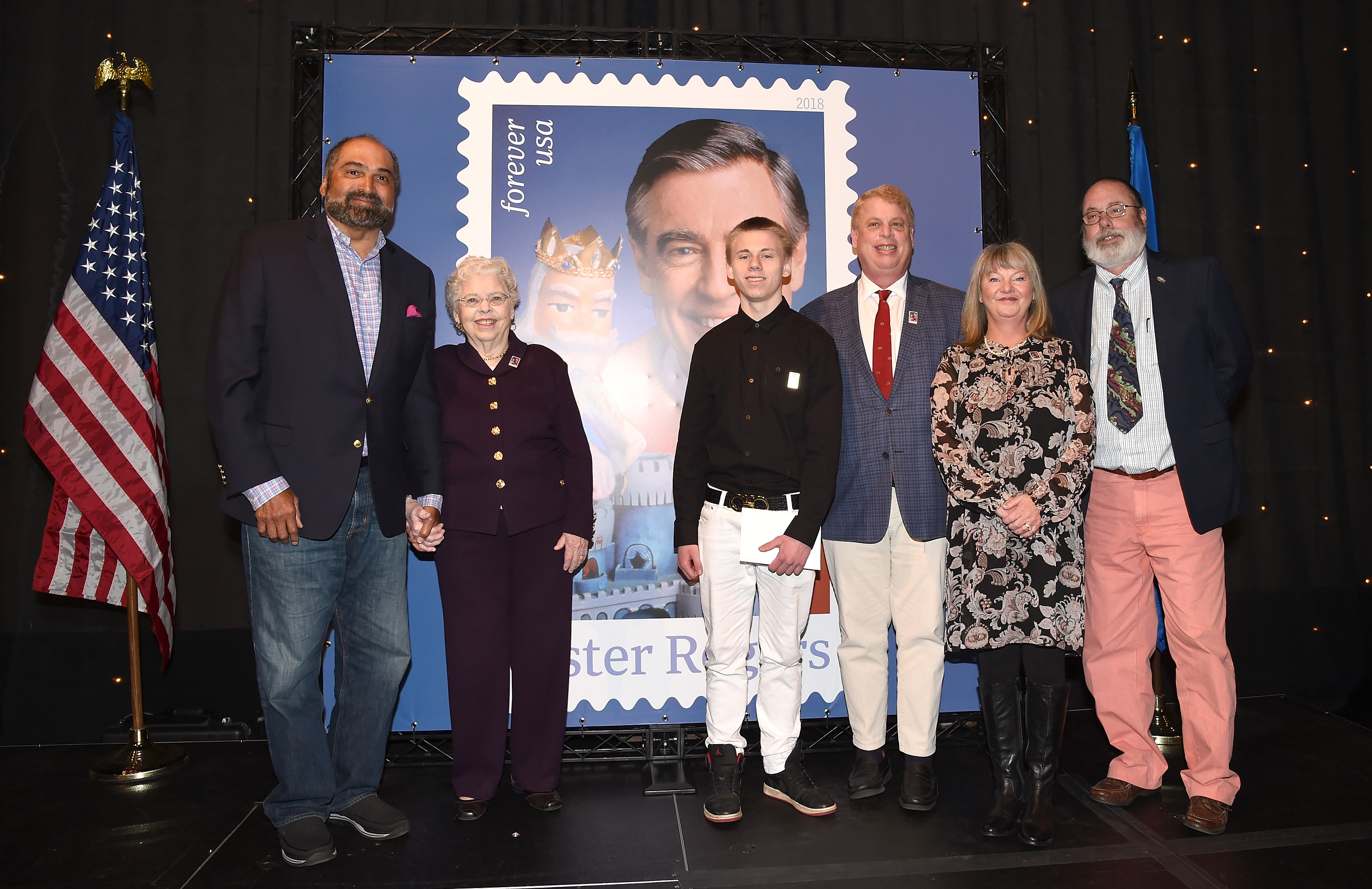 Joanne Rogers and former Pittsburgh Steeler Franco Harris pose for a photo with other family members during the U.S. Postal Service Dedication of the Mister Rogers Forever Stamp at WQED's Fred Rogers Studio on March 23, 2018 in Pittsburgh, Pennsylvania.  | Source: Getty Images