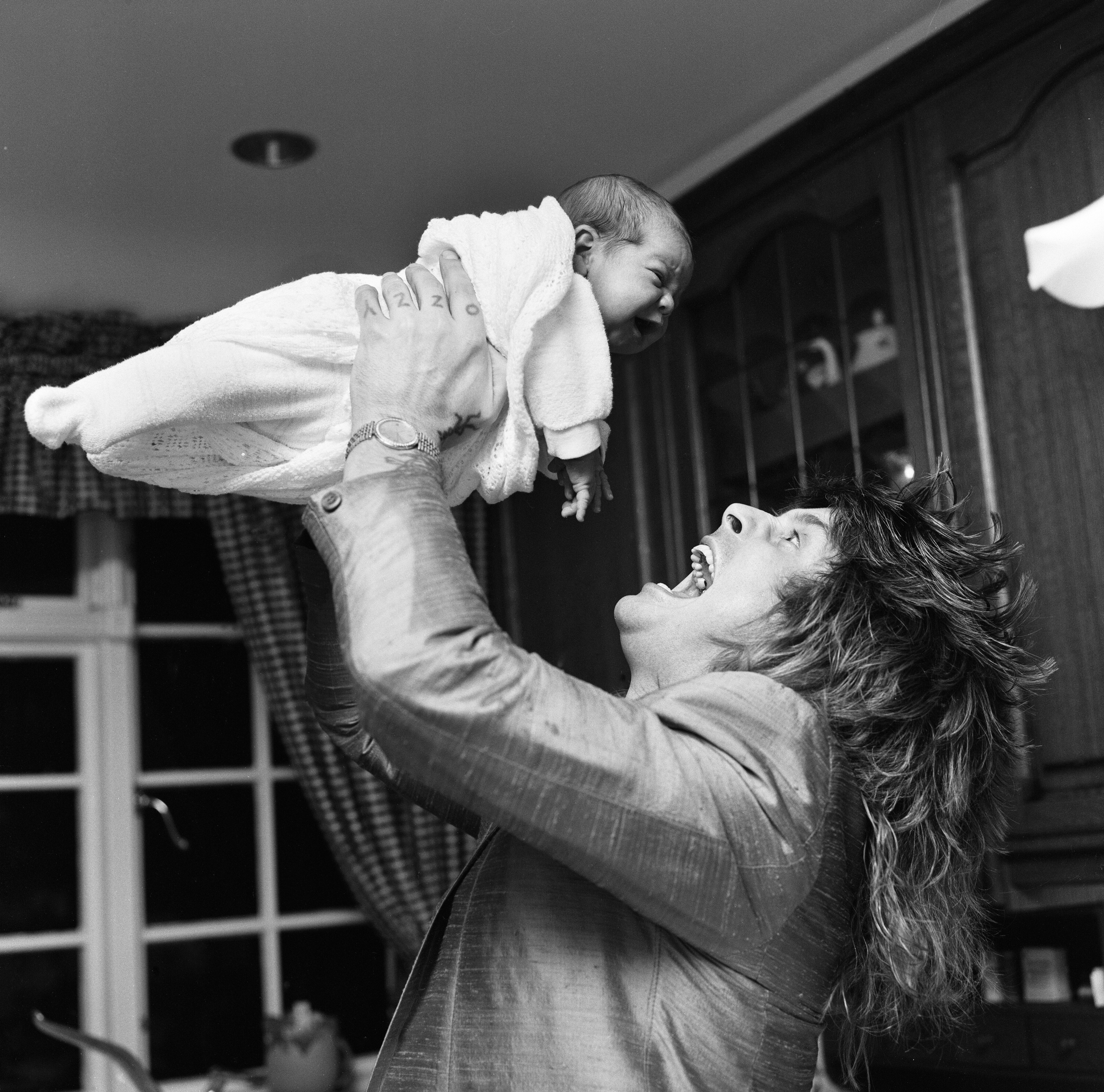 Ozzy Osbourne playfully bonding with his newly born son Jack Osbourne on November 25, 1985. | Source: Getty Images
