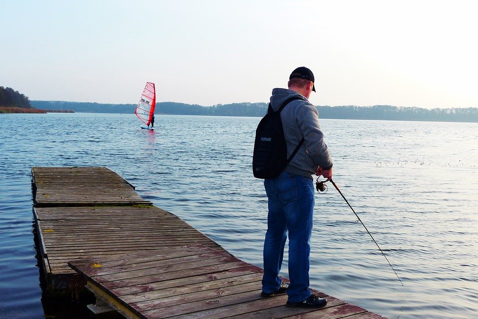 A man at a lake, attempting to fish | Photo: Pixabay