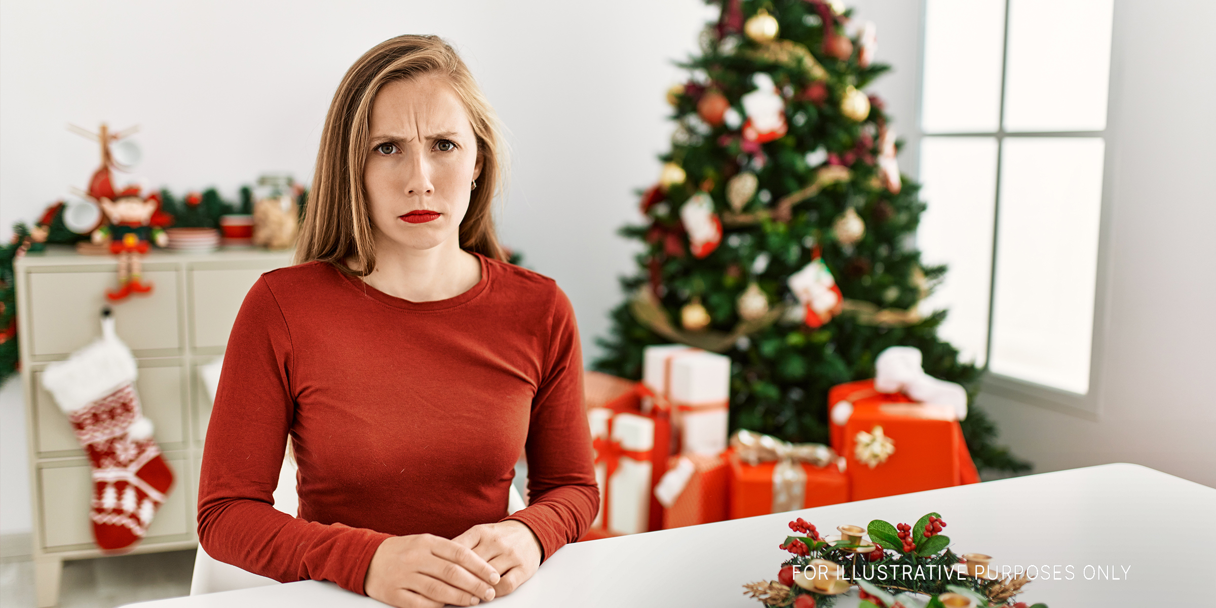 An angry woman standing in front of a Christmas tree | Source: Shutterstock