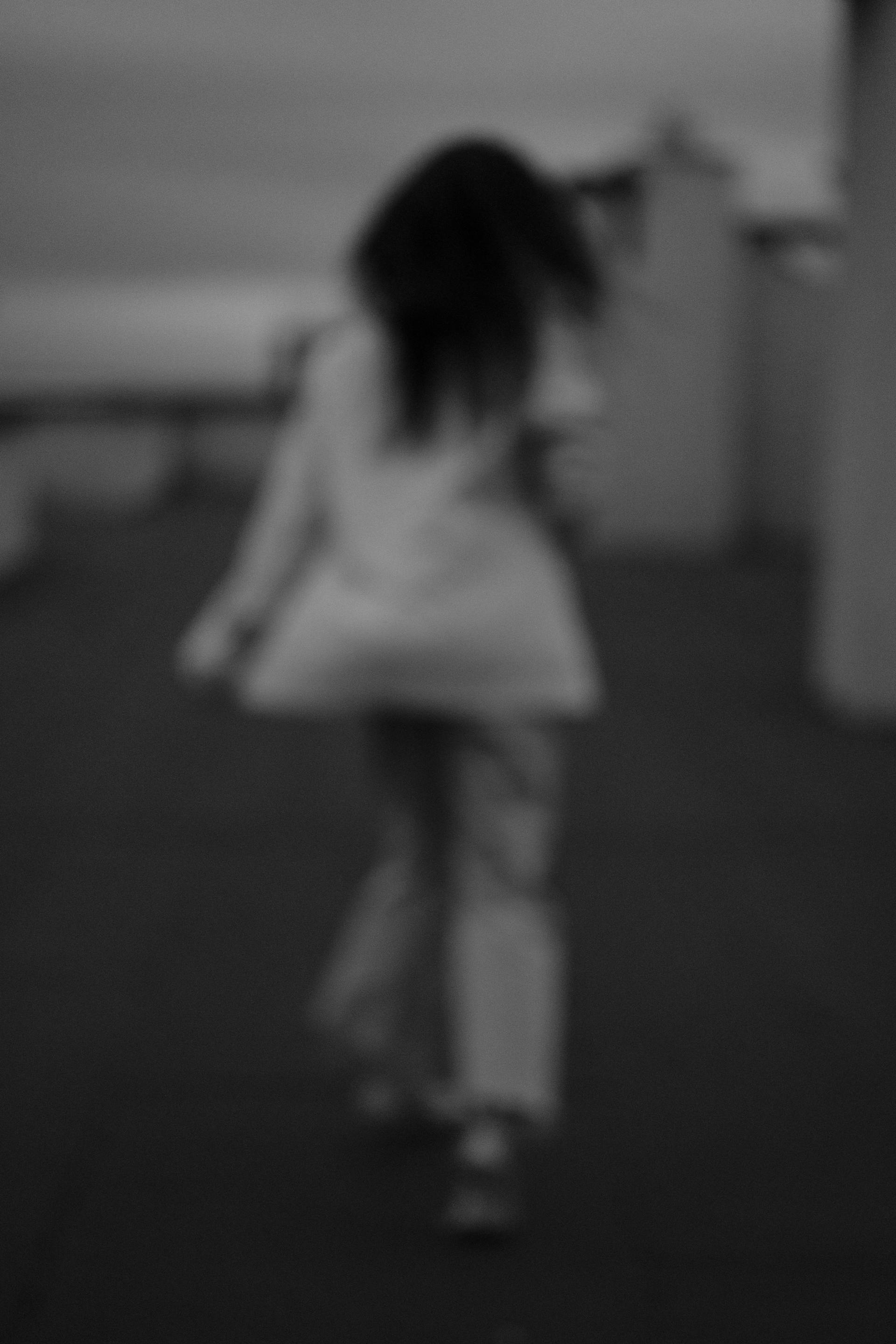 A grayscale blurred shot of a woman running away | Source: Pexels