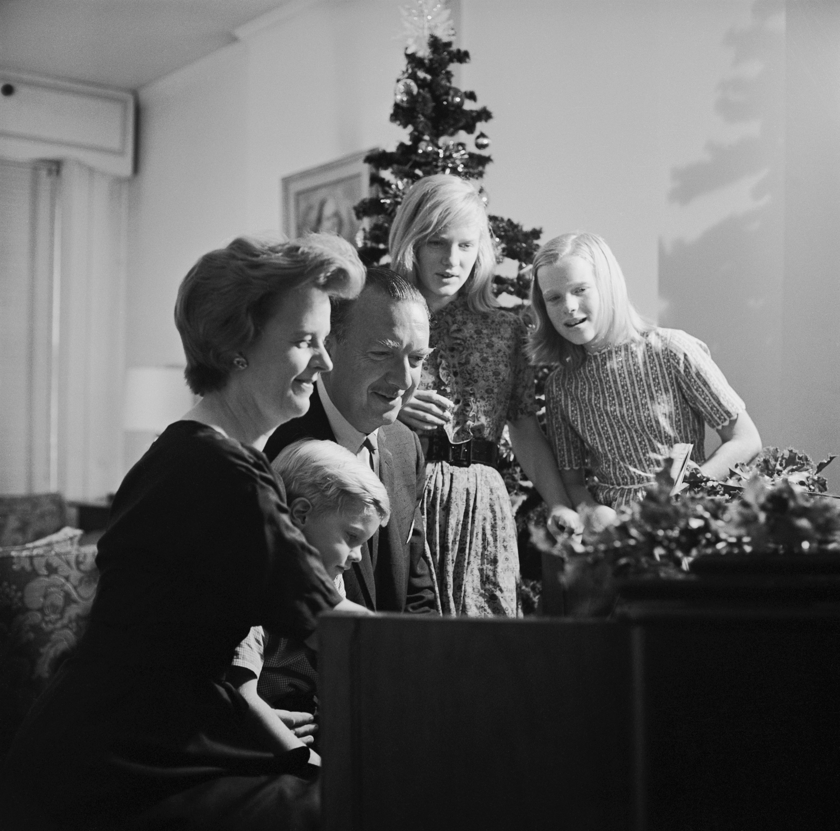 Walter Cronkite and his family gather around the piano at Christmas to sing. | Source: Getty Images