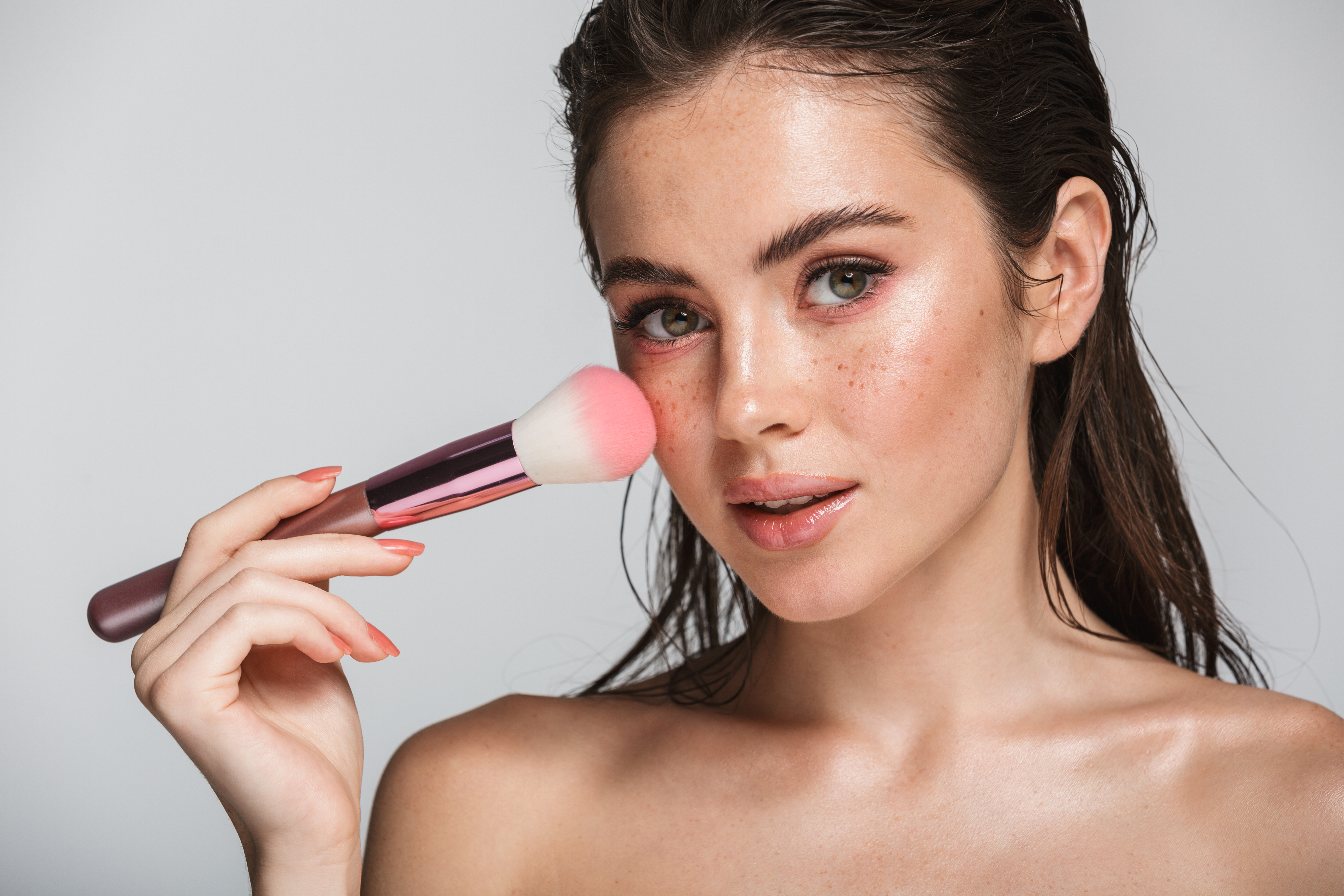 A model holding a makeup brush | Source: Shutterstock