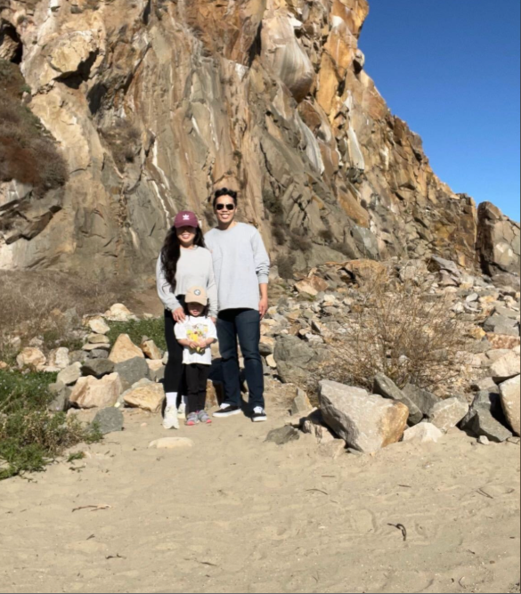Alex Duong stands with his wife Christina and their daughter Everest against a rugged cliffside, the family smiling together during a sunny outdoor outing. | Source: GoFundMe